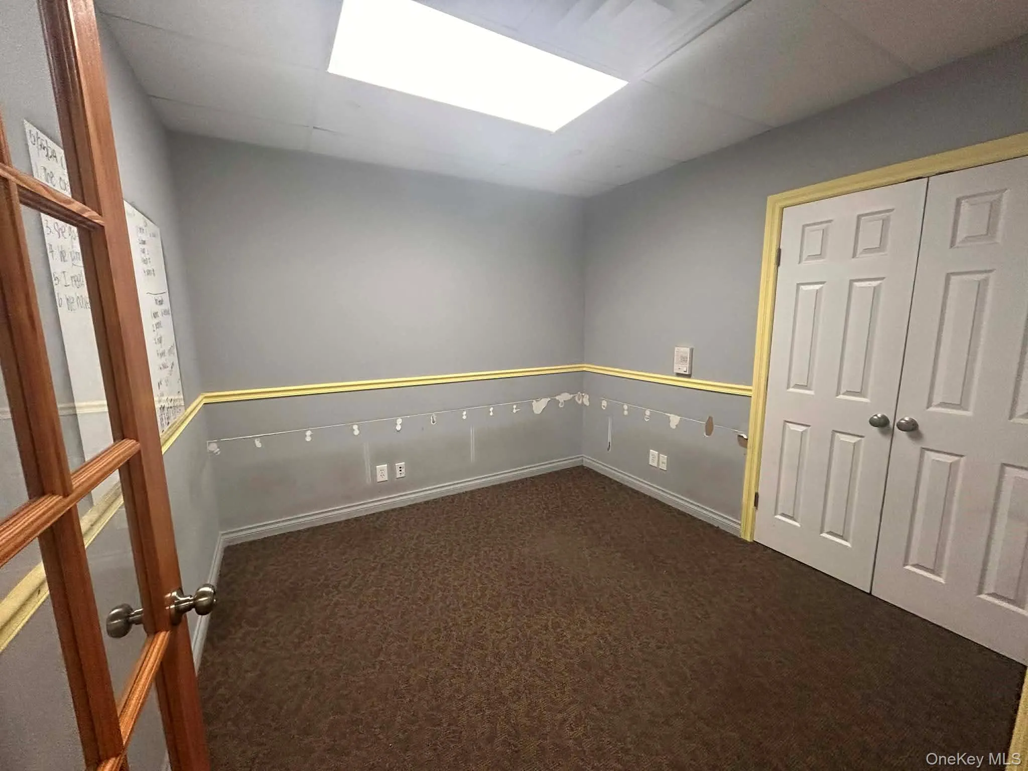 Empty room with dark carpet and a drop ceiling Empty room with dark carpet and a drop ceiling