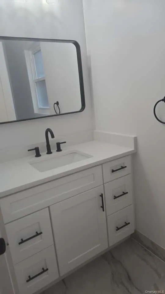 Bathroom with light marble finish flooring and vanity Bathroom with light marble finish flooring and vanity