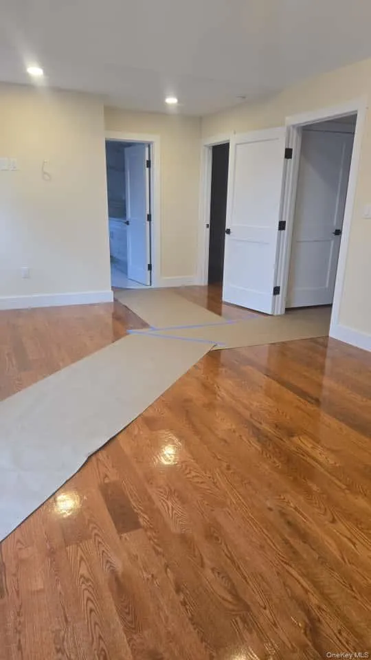 Unfurnished room with wood finished floors and recessed lighting Unfurnished room with wood finished floors and recessed lighting