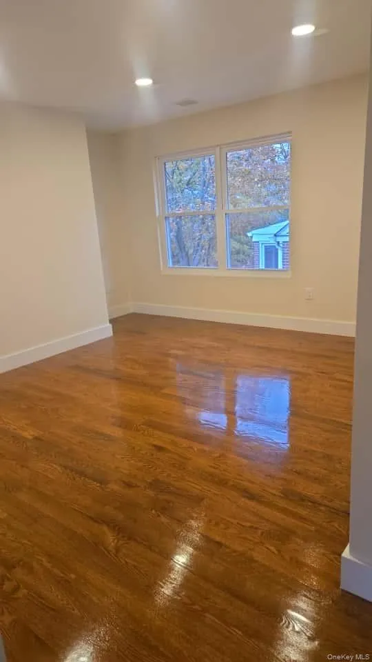 Empty room featuring dark wood-type flooring, recessed lighting, and healthy amount of natural light Empty room featuring dark wood-type flooring, recessed lighting, and healthy amount of natural light