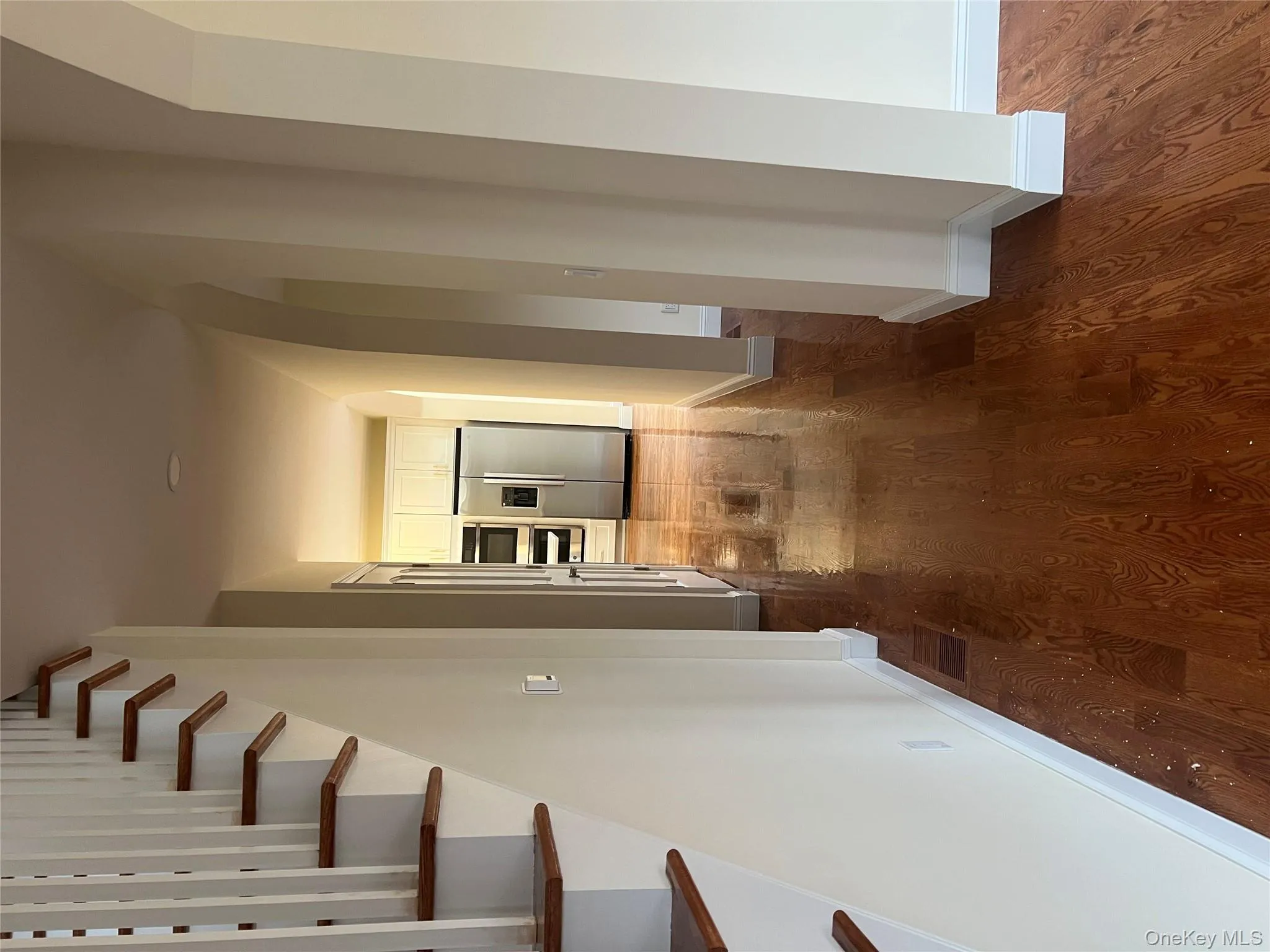 Hall with stairs, arched walkways, and dark wood-style floors Hall with stairs, arched walkways, and dark wood-style floors