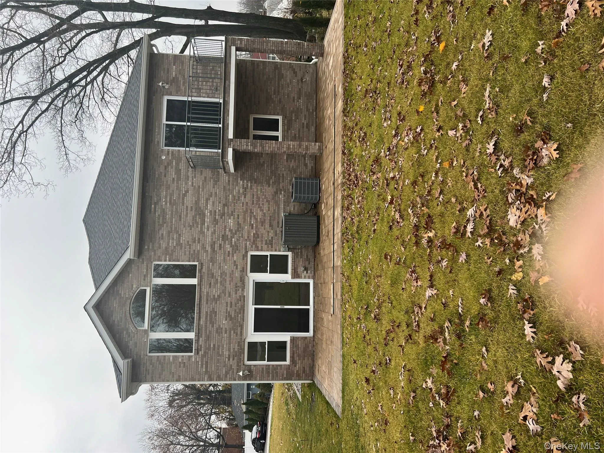 Rear view of property with a patio area, a balcony, a yard, and brick siding Rear view of property with a patio area, a balcony, a yard, and brick siding