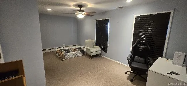 Office area with a ceiling fan, light colored carpet, a baseboard heating unit, and recessed lighting Office area with a ceiling fan, light colored carpet, a baseboard heating unit, and recessed lighting