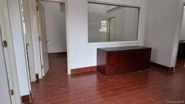 Corridor with baseboards and wood tiled floors Corridor with baseboards and wood tiled floors