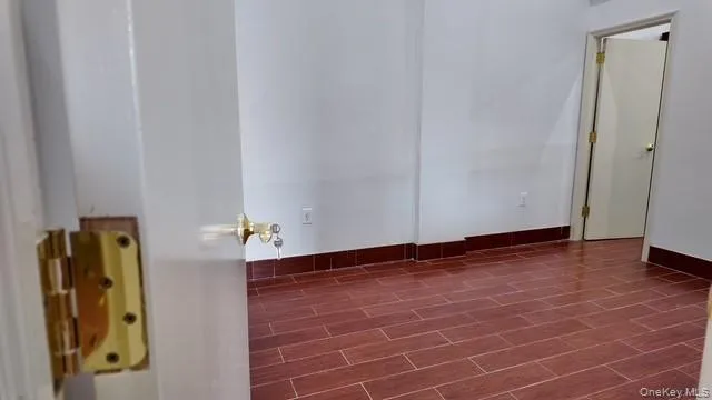 Unfurnished room featuring baseboards and wood finish floors Unfurnished room featuring baseboards and wood finish floors