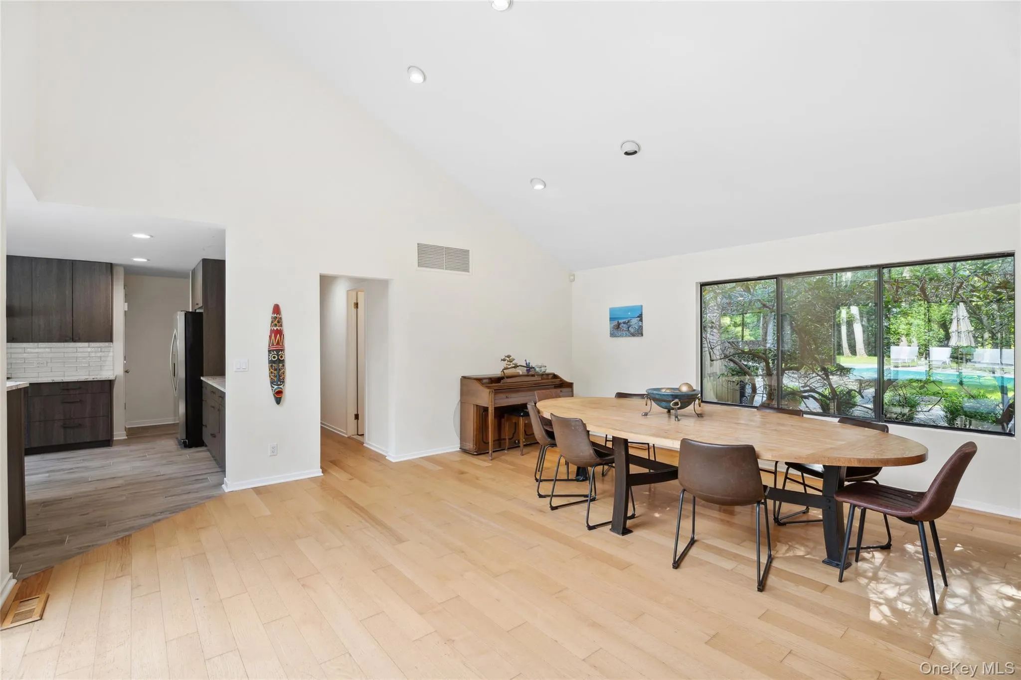 Dining space featuring high vaulted ceiling, light wood-style flooring, and recessed lighting Dining space featuring high vaulted ceiling, light wood-style flooring, and recessed lighting