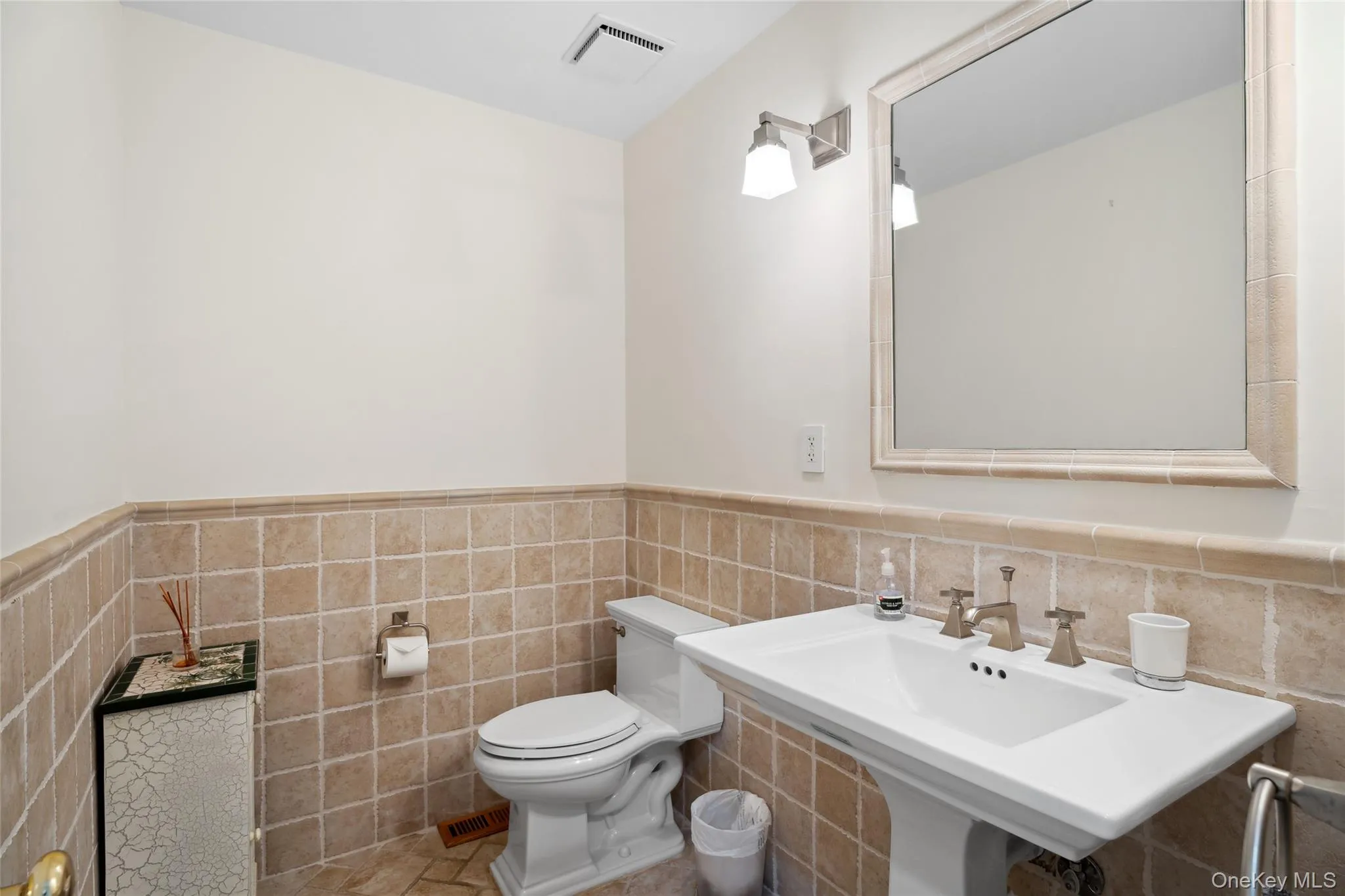 Half bath featuring wainscoting and tile walls Half bath featuring wainscoting and tile walls