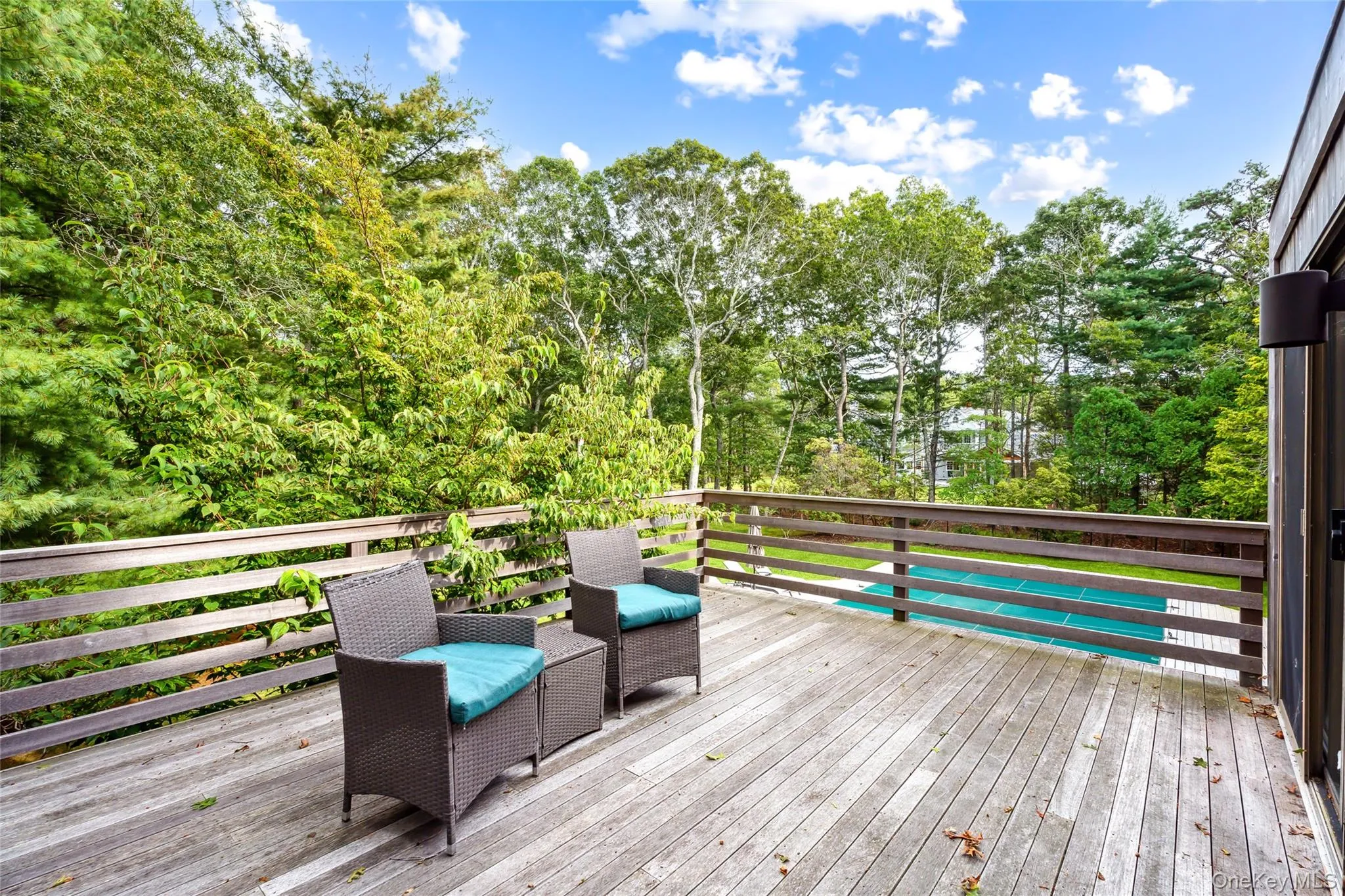 Wooden terrace featuring view of wooded area Wooden terrace featuring view of wooded area
