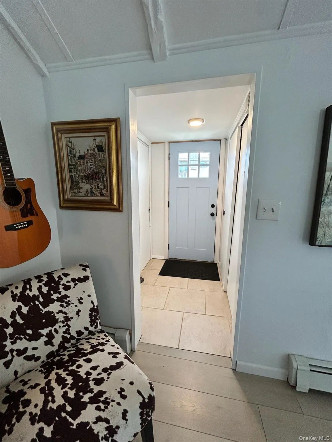 Foyer with baseboard heating and light tile patterned flooring Foyer with baseboard heating and light tile patterned flooring