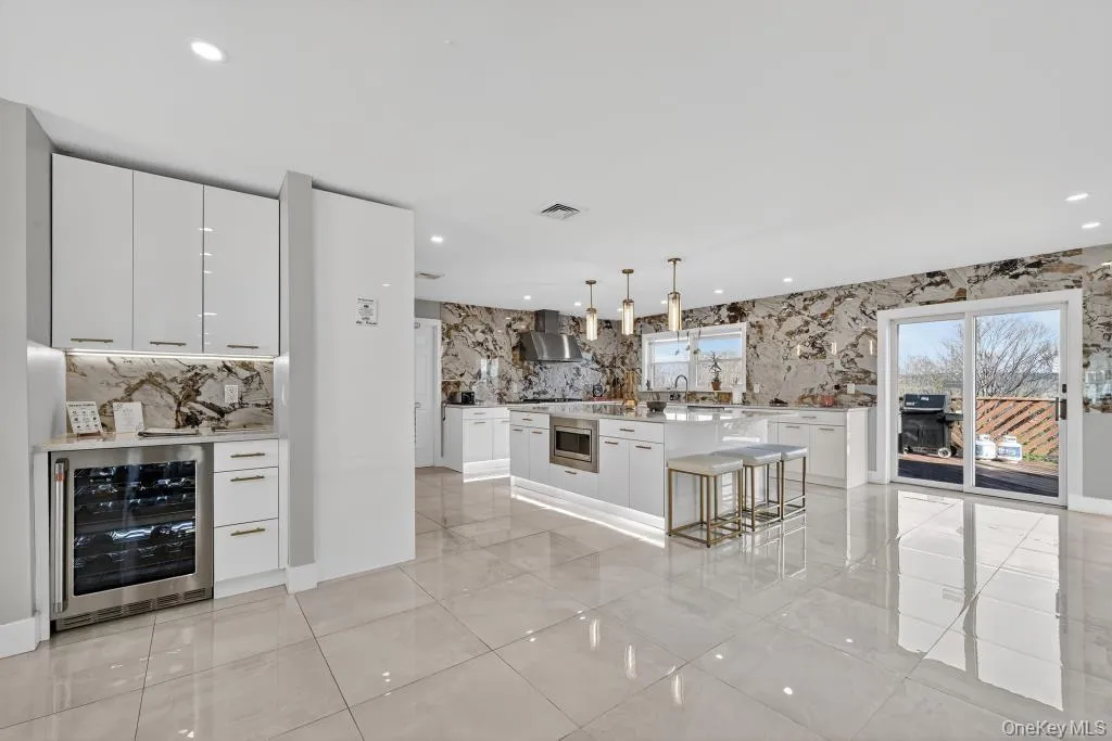 Kitchen with center island and sliding glass doors to backyard Kitchen with center island and sliding glass doors to backyard