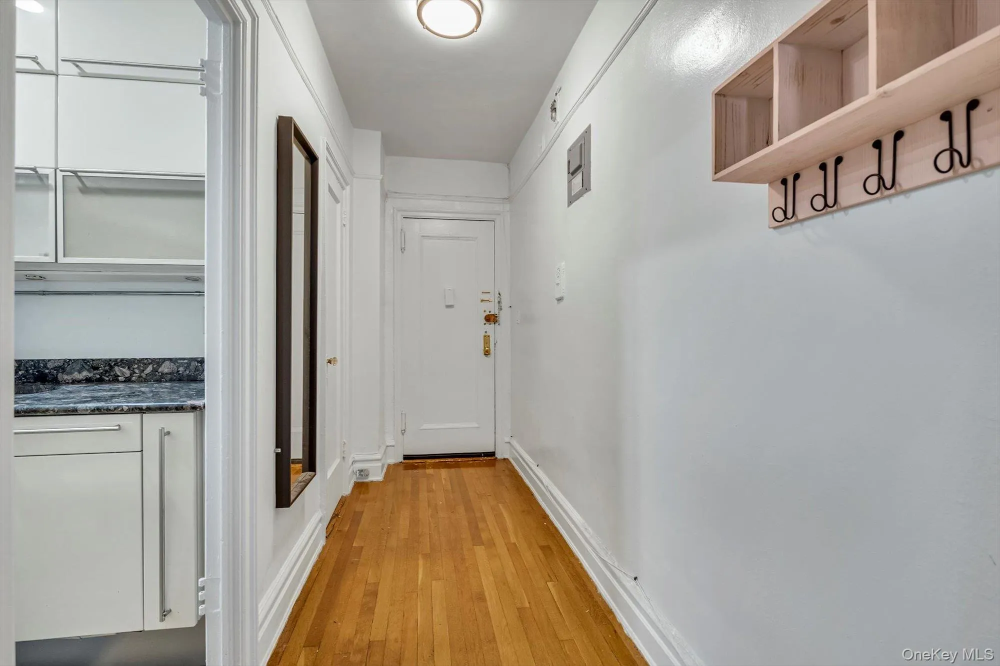 Hall with light wood-style flooring and baseboards Hall with light wood-style flooring and baseboards