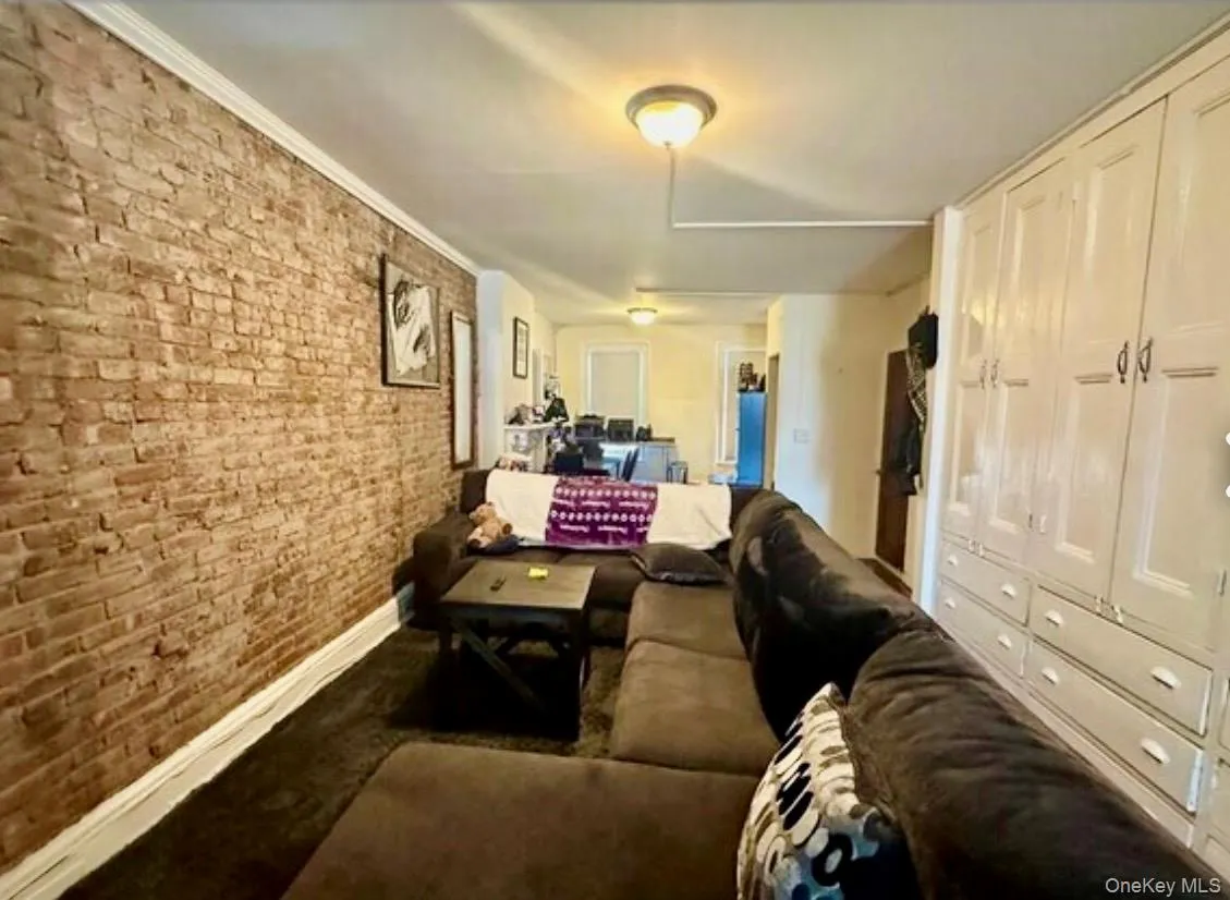 Living room with brick wall and baseboards Living room with brick wall and baseboards