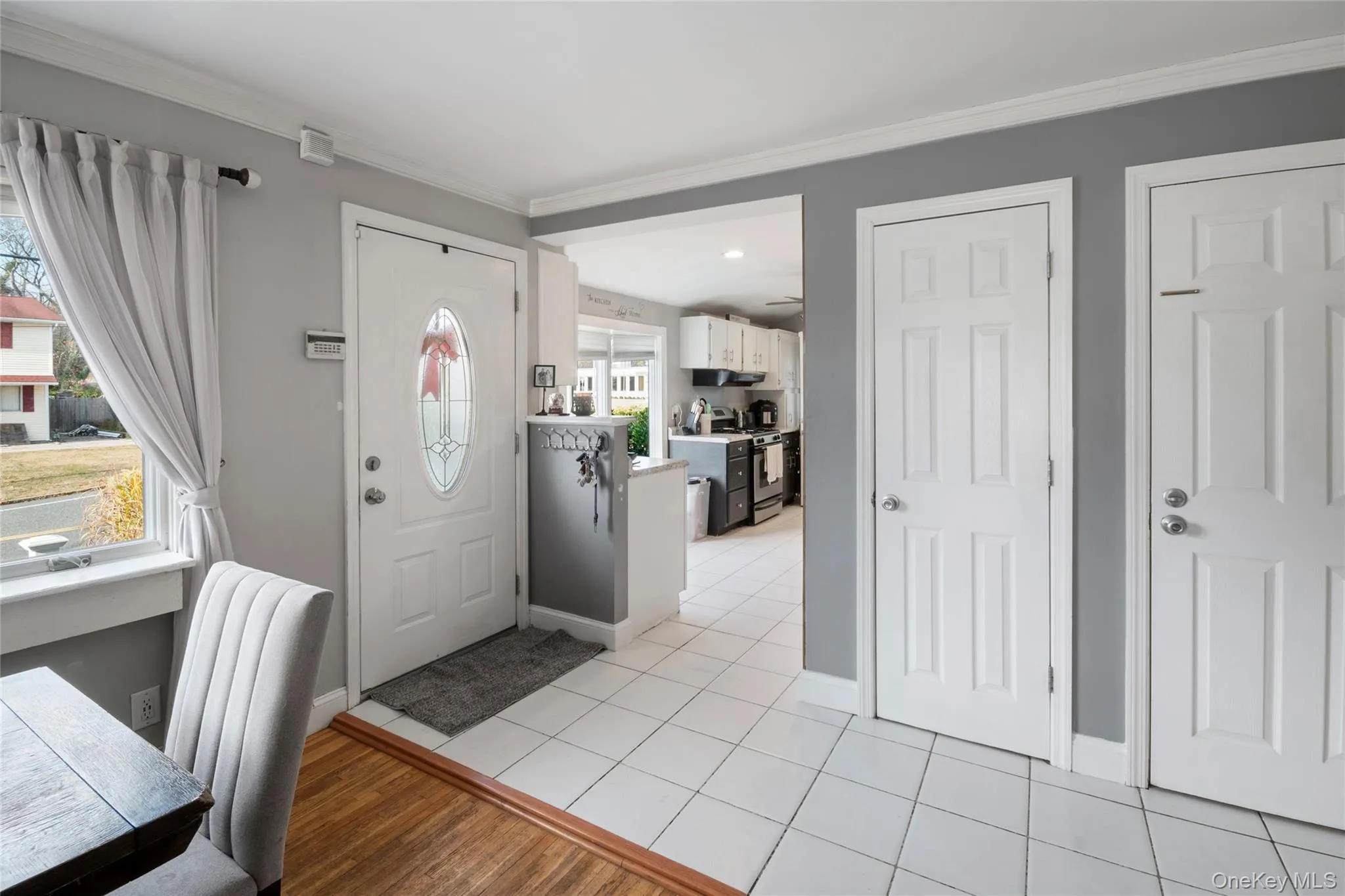Entryway with light wood-style flooring and crown molding Entryway with light wood-style flooring and crown molding