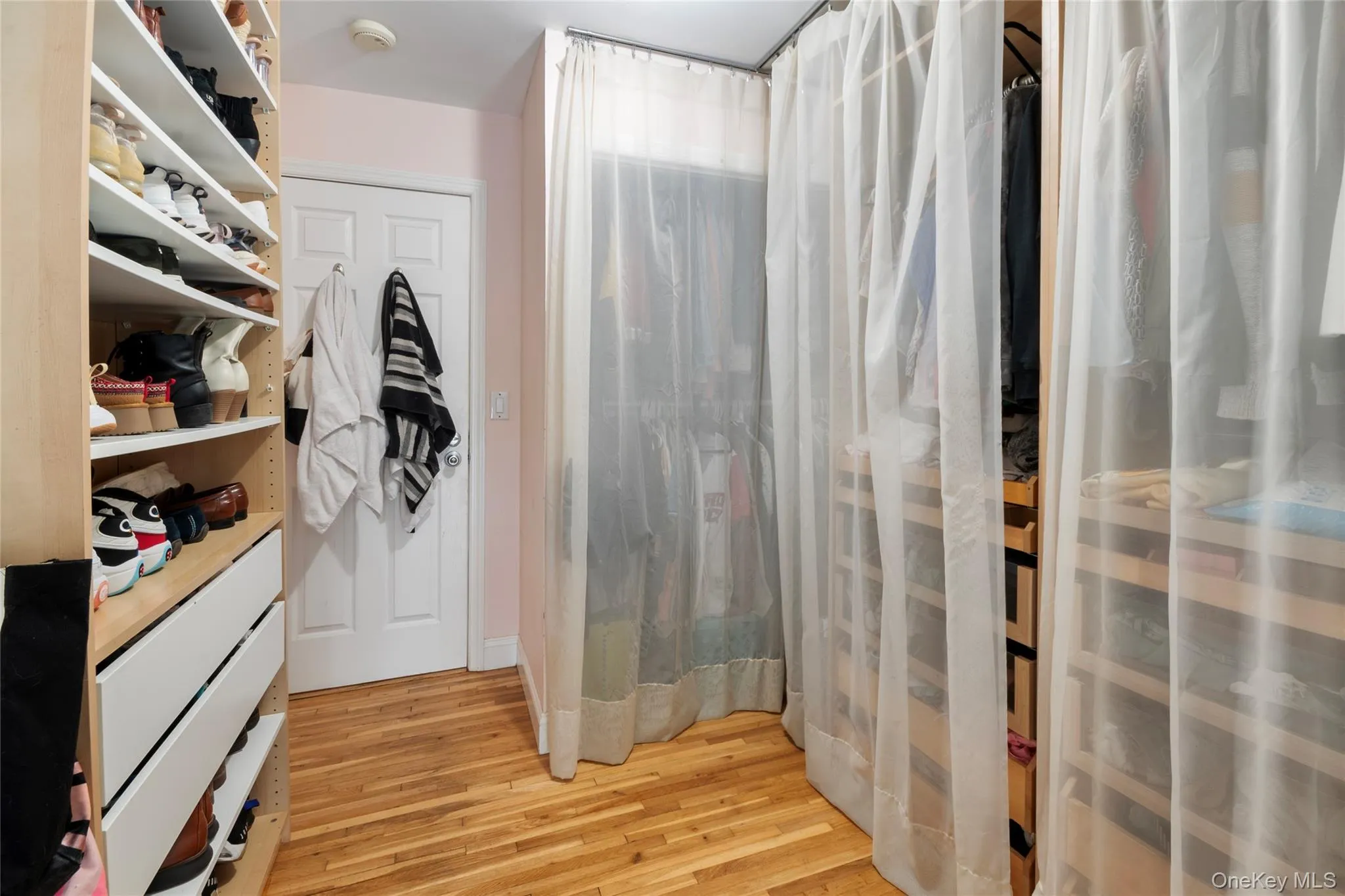 Spacious closet with light wood-type flooring Spacious closet with light wood-type flooring