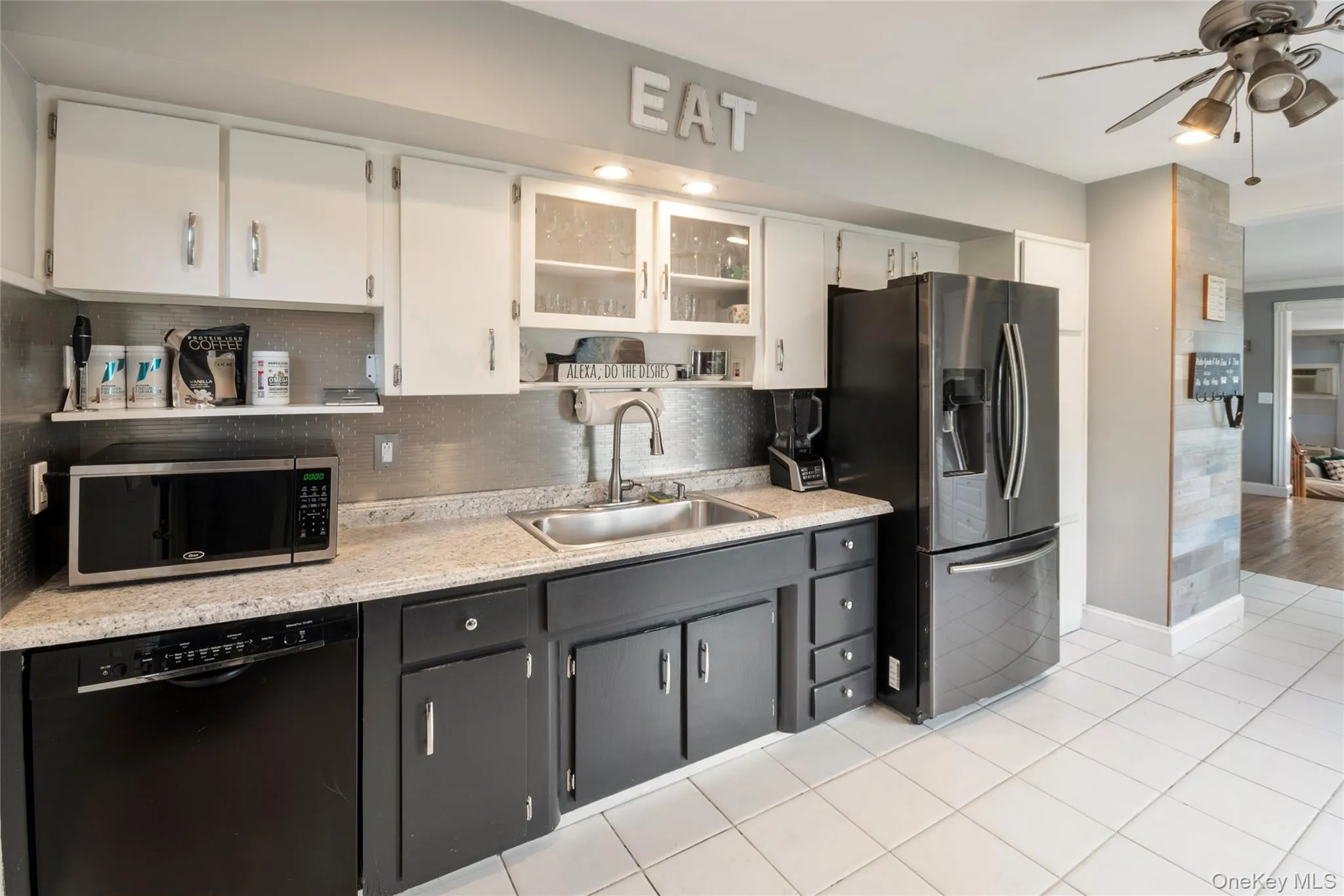 Kitchen with open shelves, white cabinetry, appliances with stainless steel finishes, decorative backsplash, and ceiling fan Kitchen with open shelves, white cabinetry, appliances with stainless steel finishes, decorative backsplash, and ceiling fan