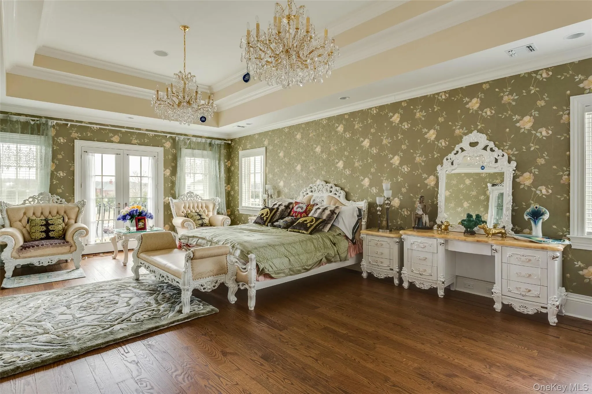 Bedroom with a raised ceiling, wallpapered walls, access to outside, ornamental molding, and dark wood-type flooring Bedroom with a raised ceiling, wallpapered walls, access to outside, ornamental molding, and dark wood-type flooring