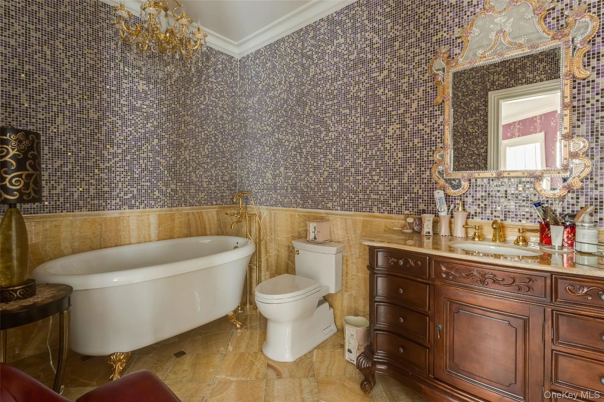Full bathroom featuring crown molding, a freestanding tub, vanity, tile walls, and a chandelier Full bathroom featuring crown molding, a freestanding tub, vanity, tile walls, and a chandelier