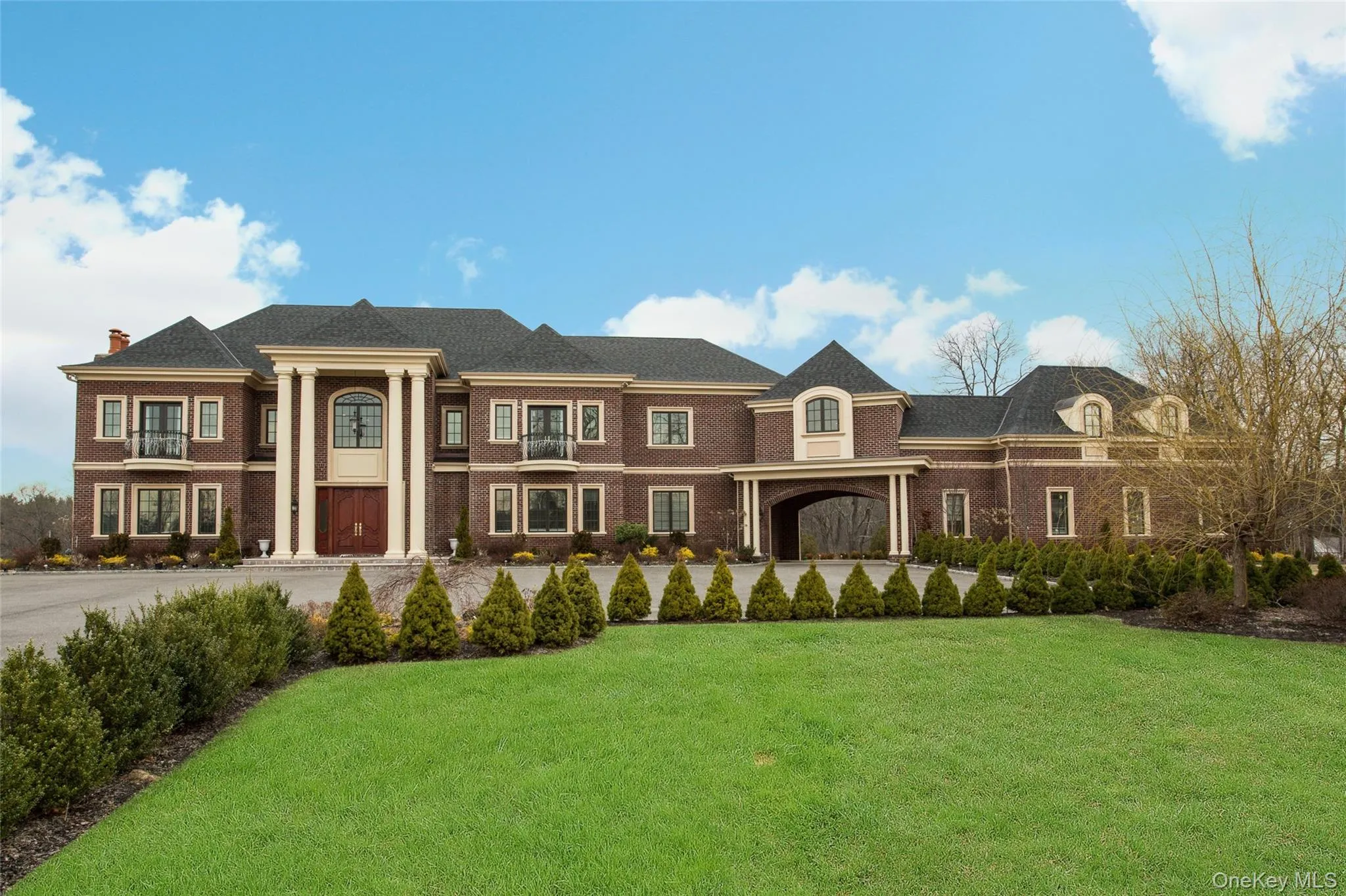 Neoclassical home with a front lawn, a chimney, and brick siding Neoclassical home with a front lawn, a chimney, and brick siding