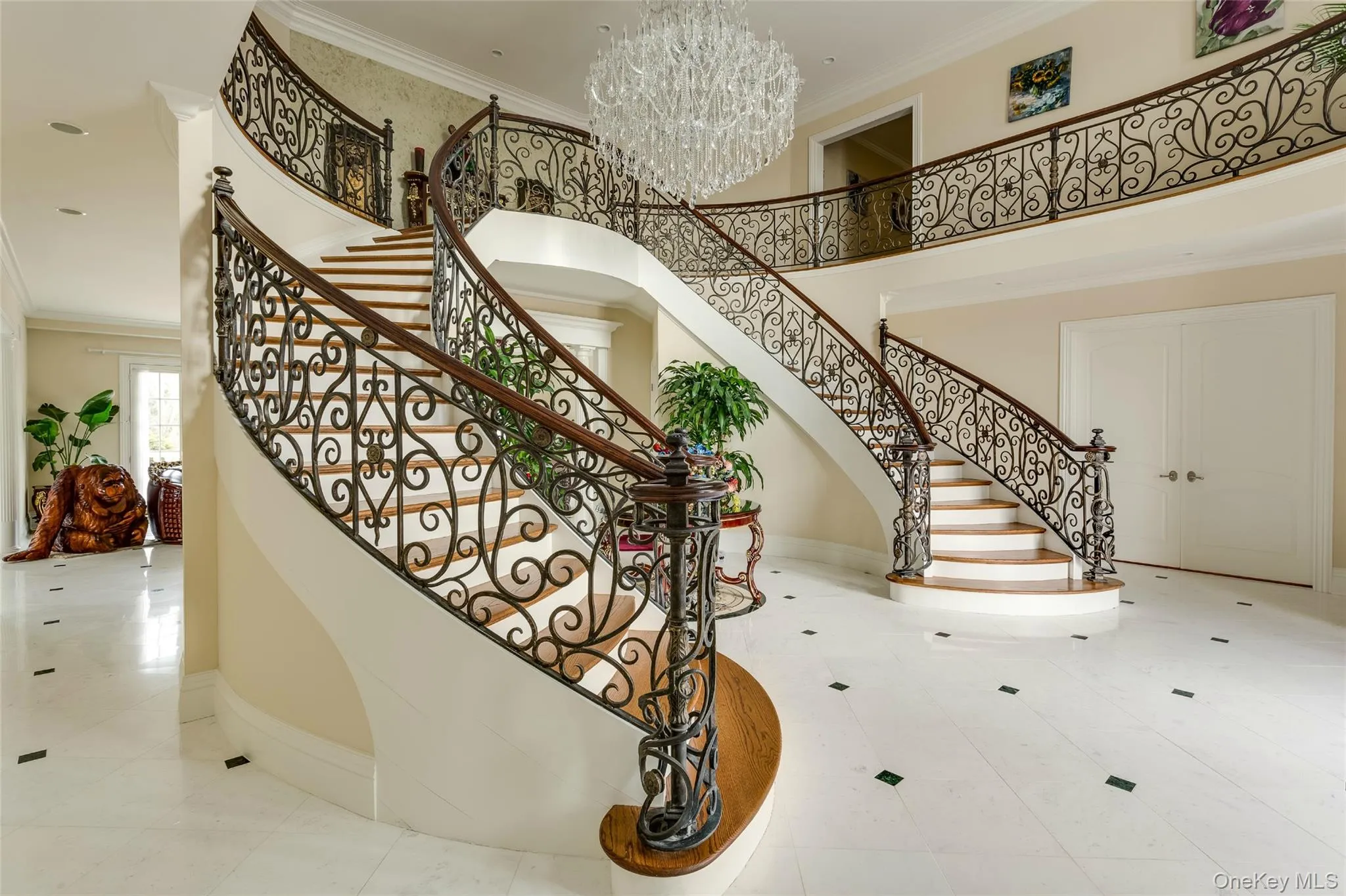 Stairway with ornamental molding, a chandelier, a towering ceiling, and tile patterned flooring Stairway with ornamental molding, a chandelier, a towering ceiling, and tile patterned flooring