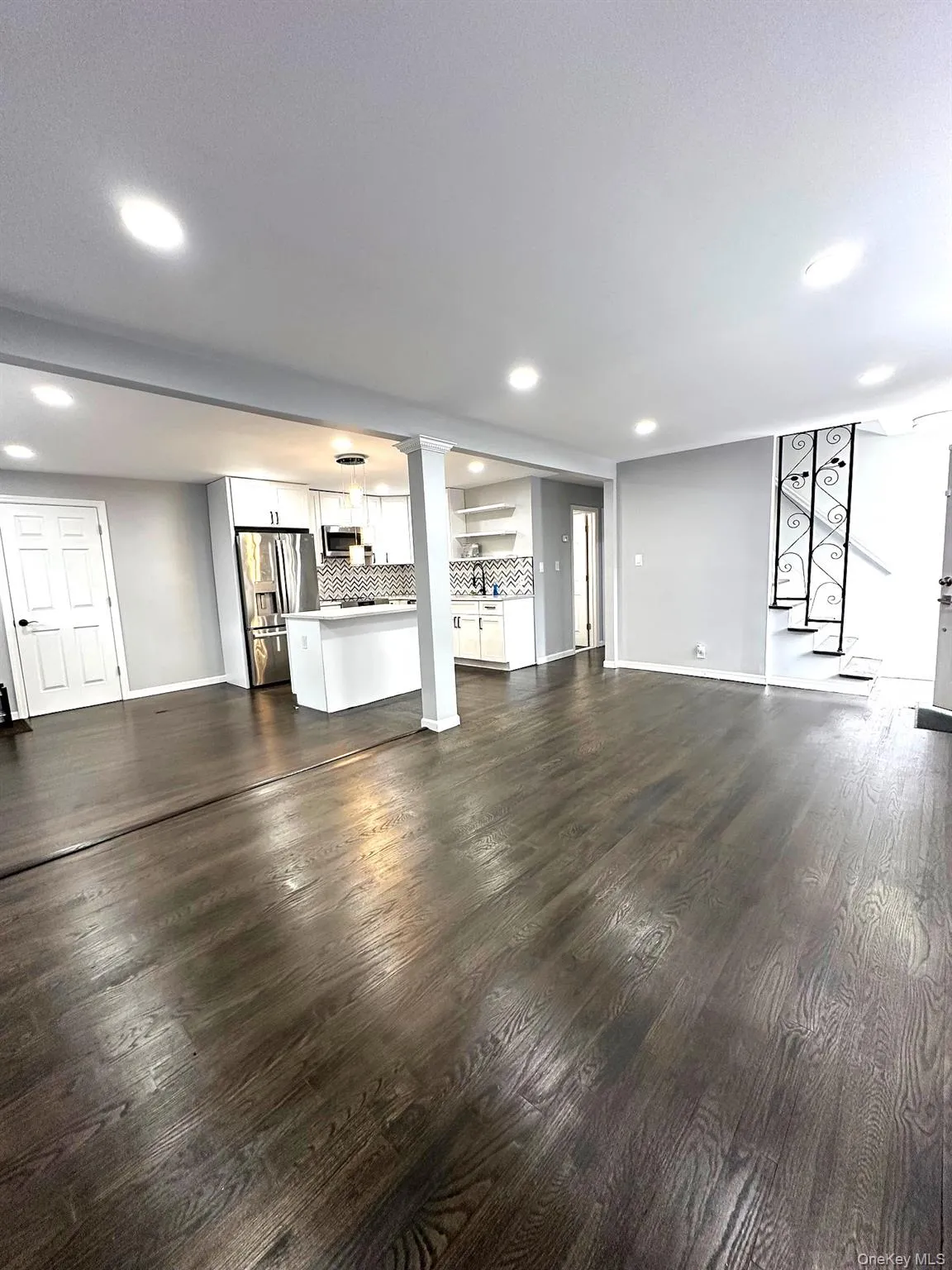 Unfurnished living room with recessed lighting and dark wood-style floors Unfurnished living room with recessed lighting and dark wood-style floors