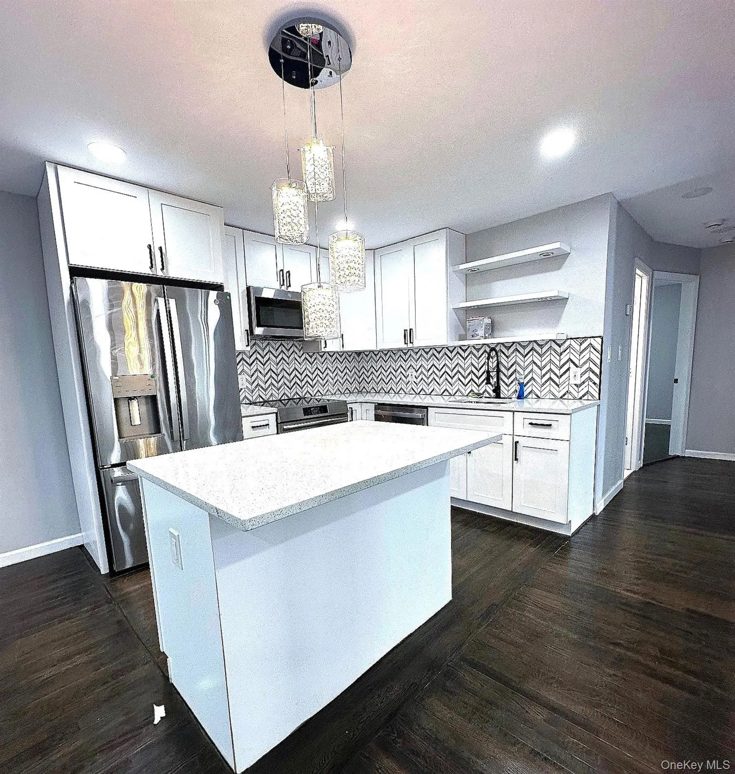 Kitchen featuring white cabinets, open shelves, hanging light fixtures, and stainless steel appliances Kitchen featuring white cabinets, open shelves, hanging light fixtures, and stainless steel appliances