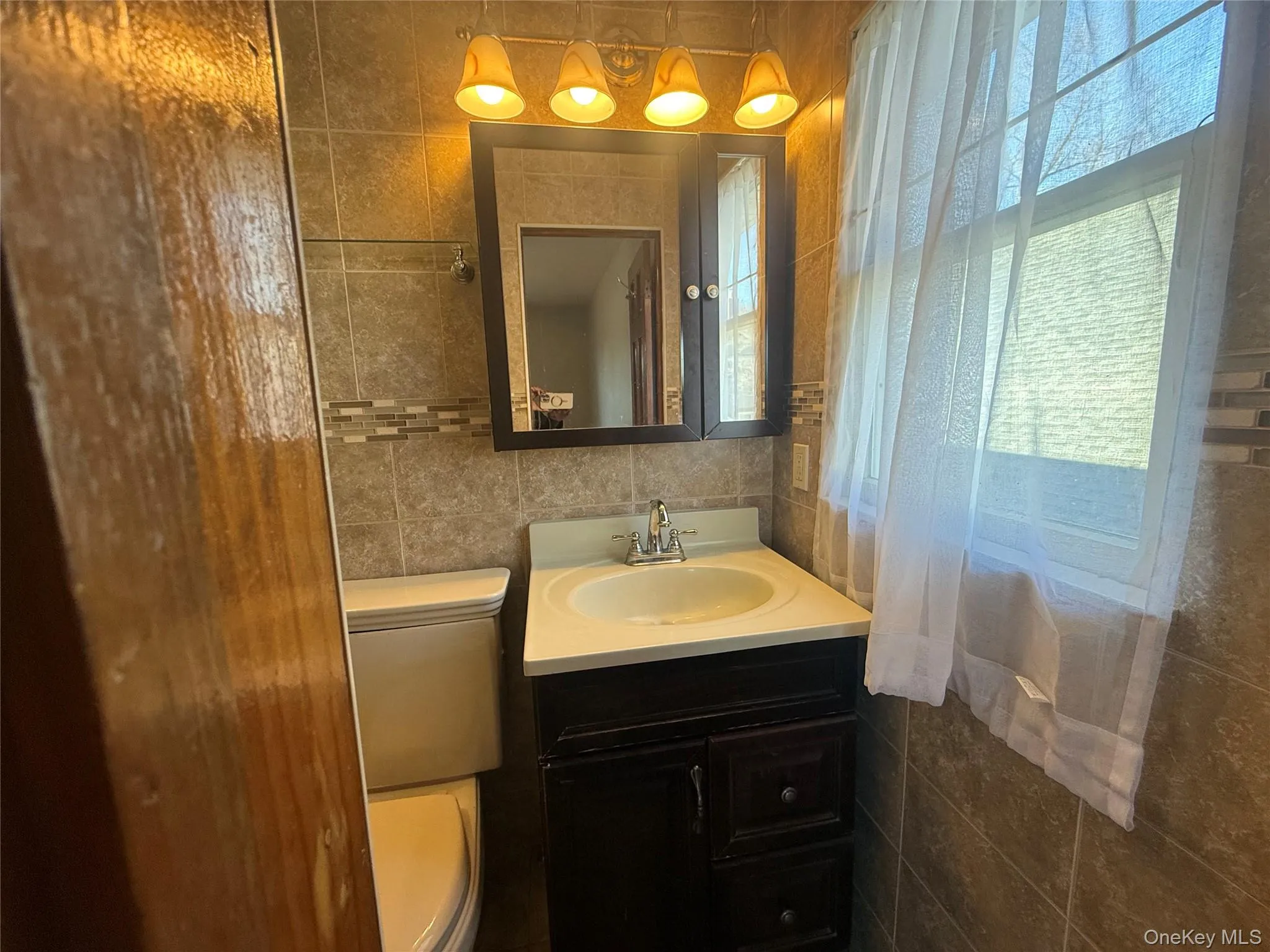 Half bath with tile walls and vanity Half bath with tile walls and vanity