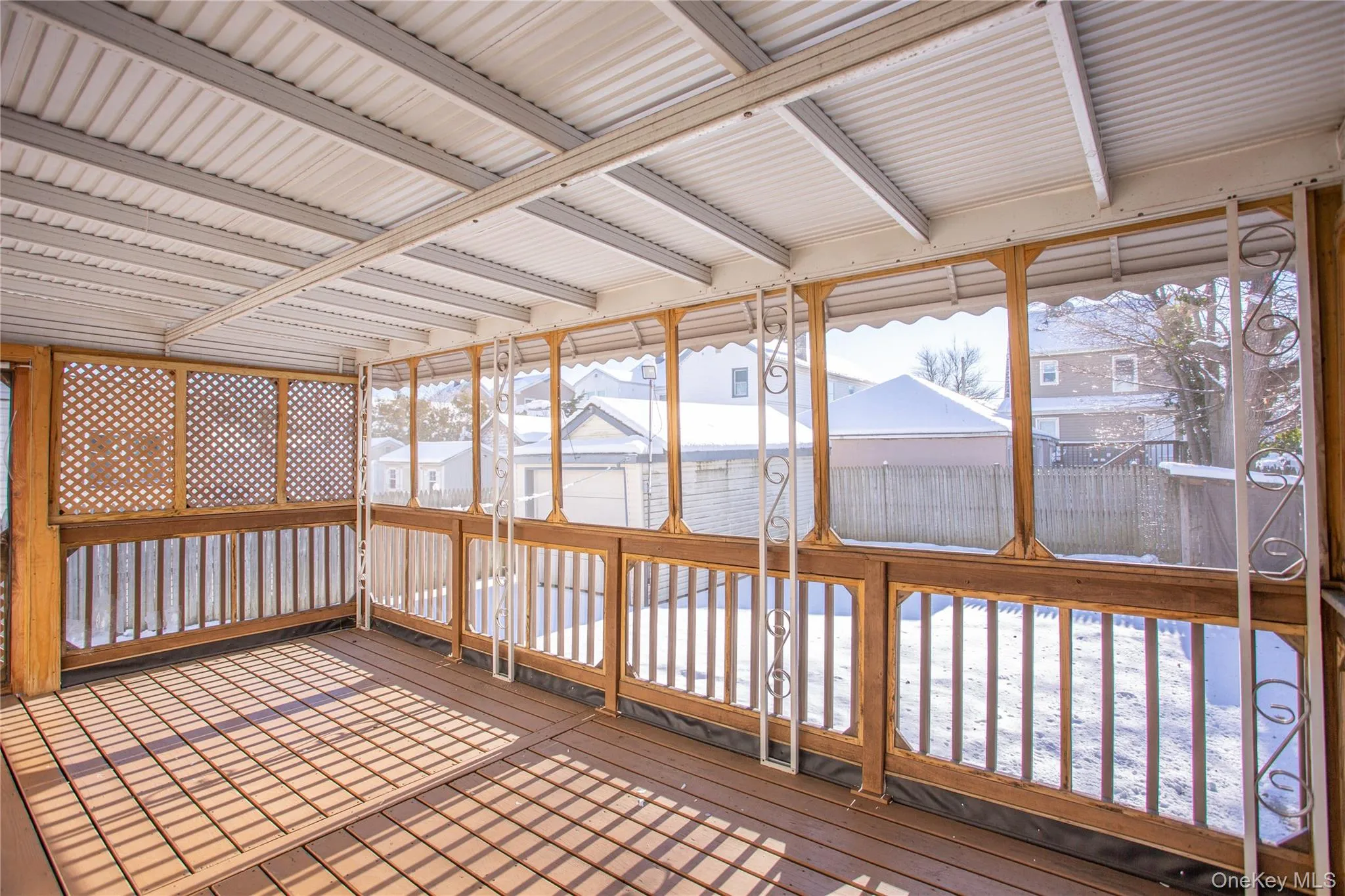Unfurnished sunroom featuring wood-type flooring and a residential view Unfurnished sunroom featuring wood-type flooring and a residential view
