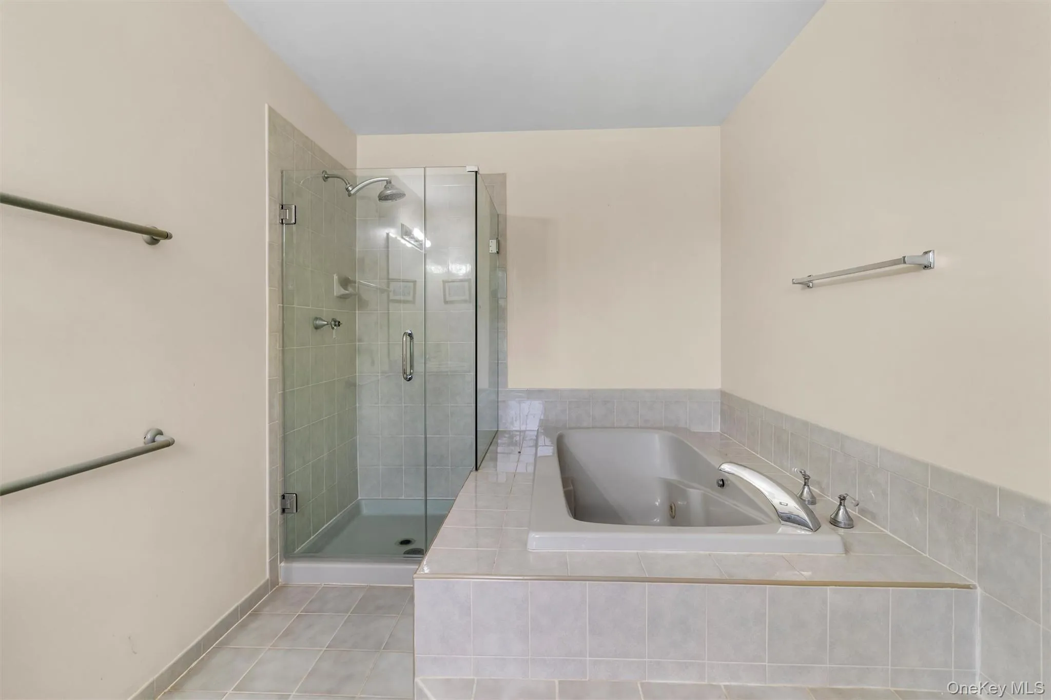 Bathroom featuring a whirlpool tub, light tile patterned flooring, and a shower stall Bathroom featuring a whirlpool tub, light tile patterned flooring, and a shower stall