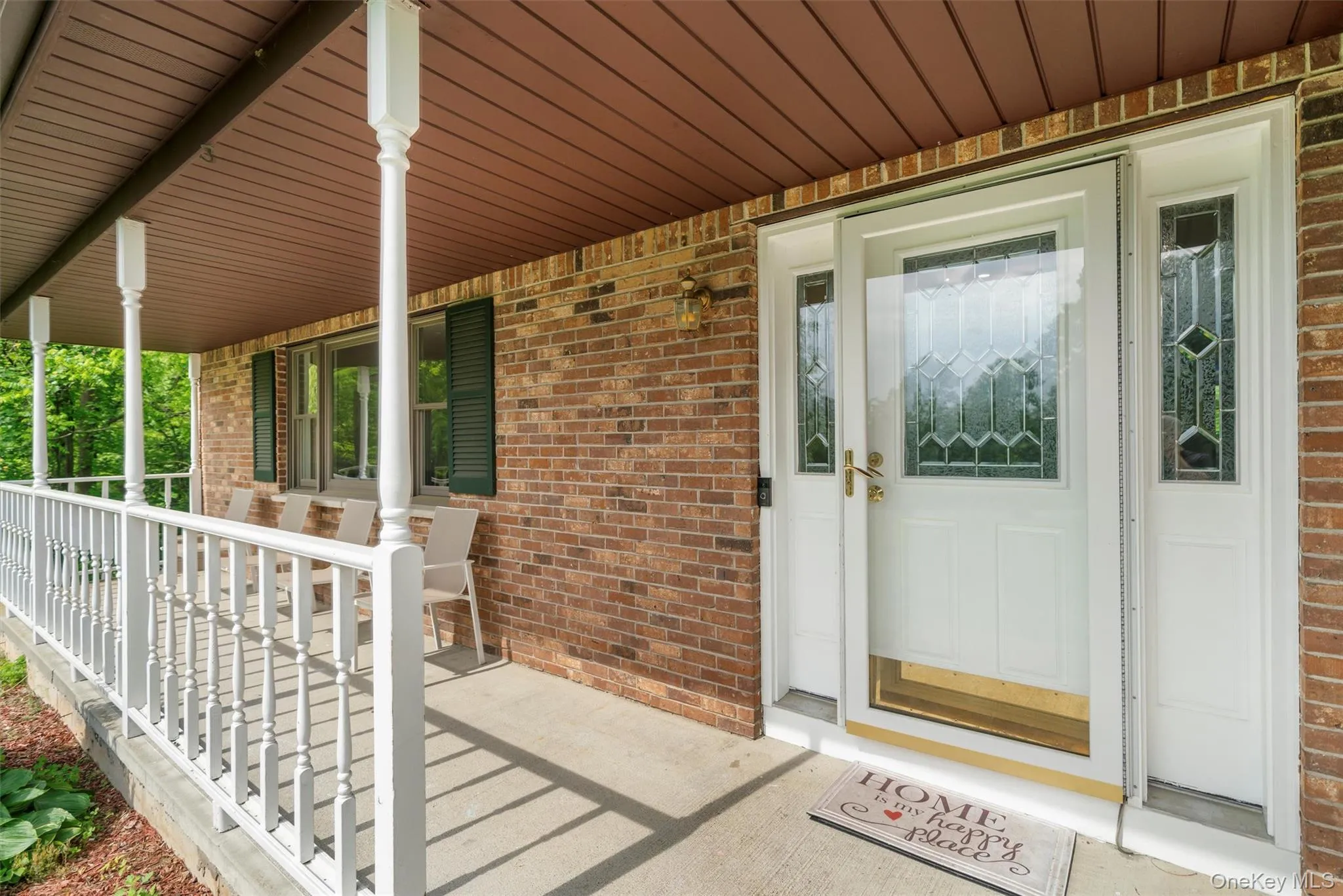Property entrance featuring a porch and brick siding Property entrance featuring a porch and brick siding
