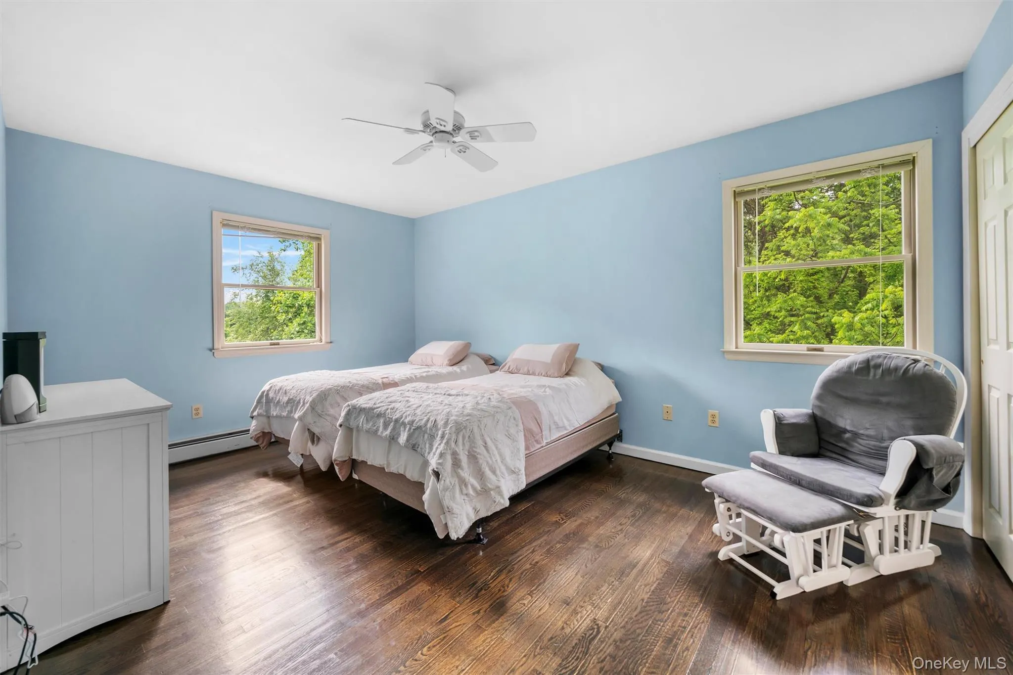 Bedroom with a baseboard heating unit, a closet, dark wood-style floors, and ceiling fan Bedroom with a baseboard heating unit, a closet, dark wood-style floors, and ceiling fan