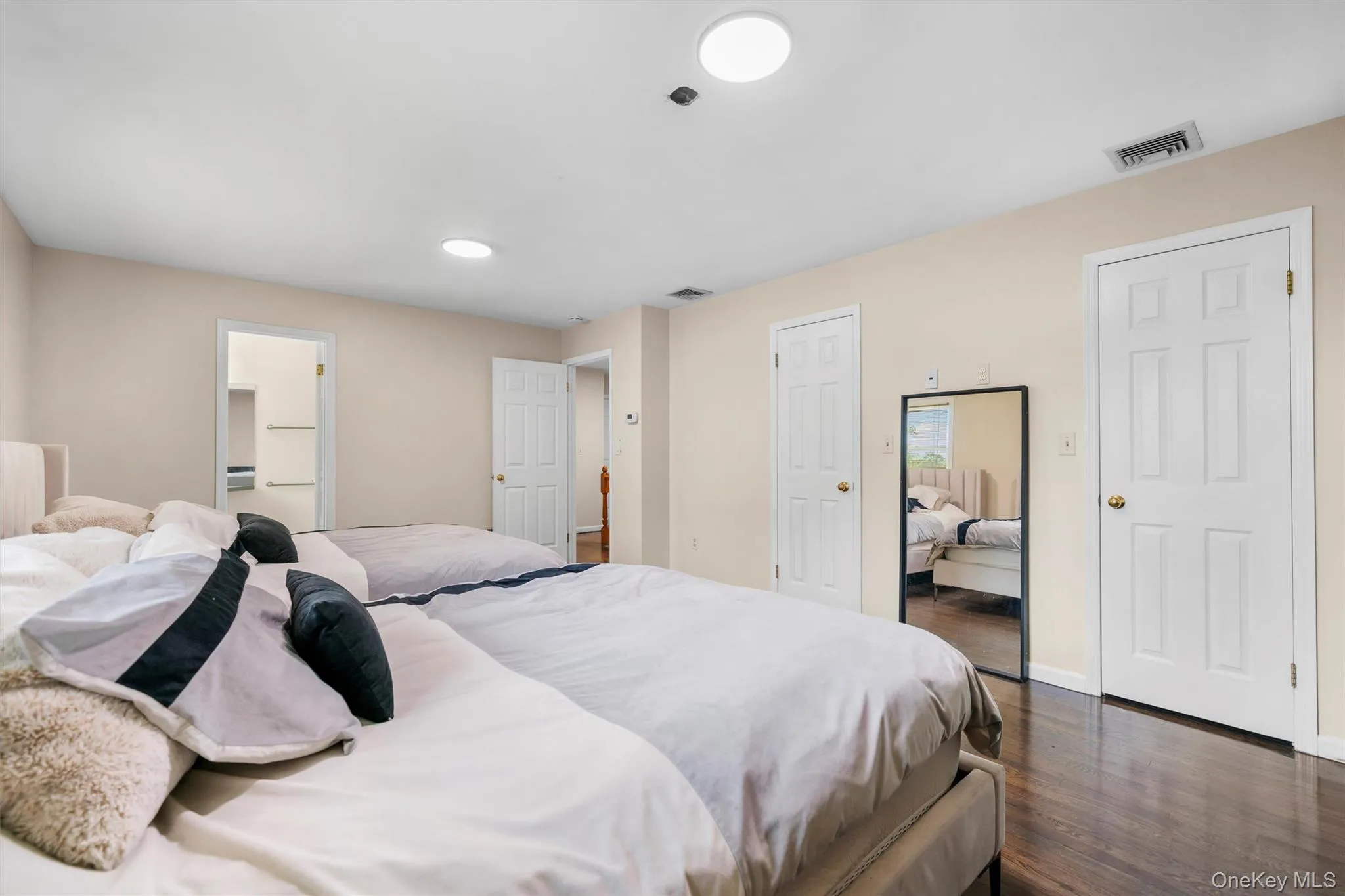 Bedroom with dark wood-style floors and two closets Bedroom with dark wood-style floors and two closets