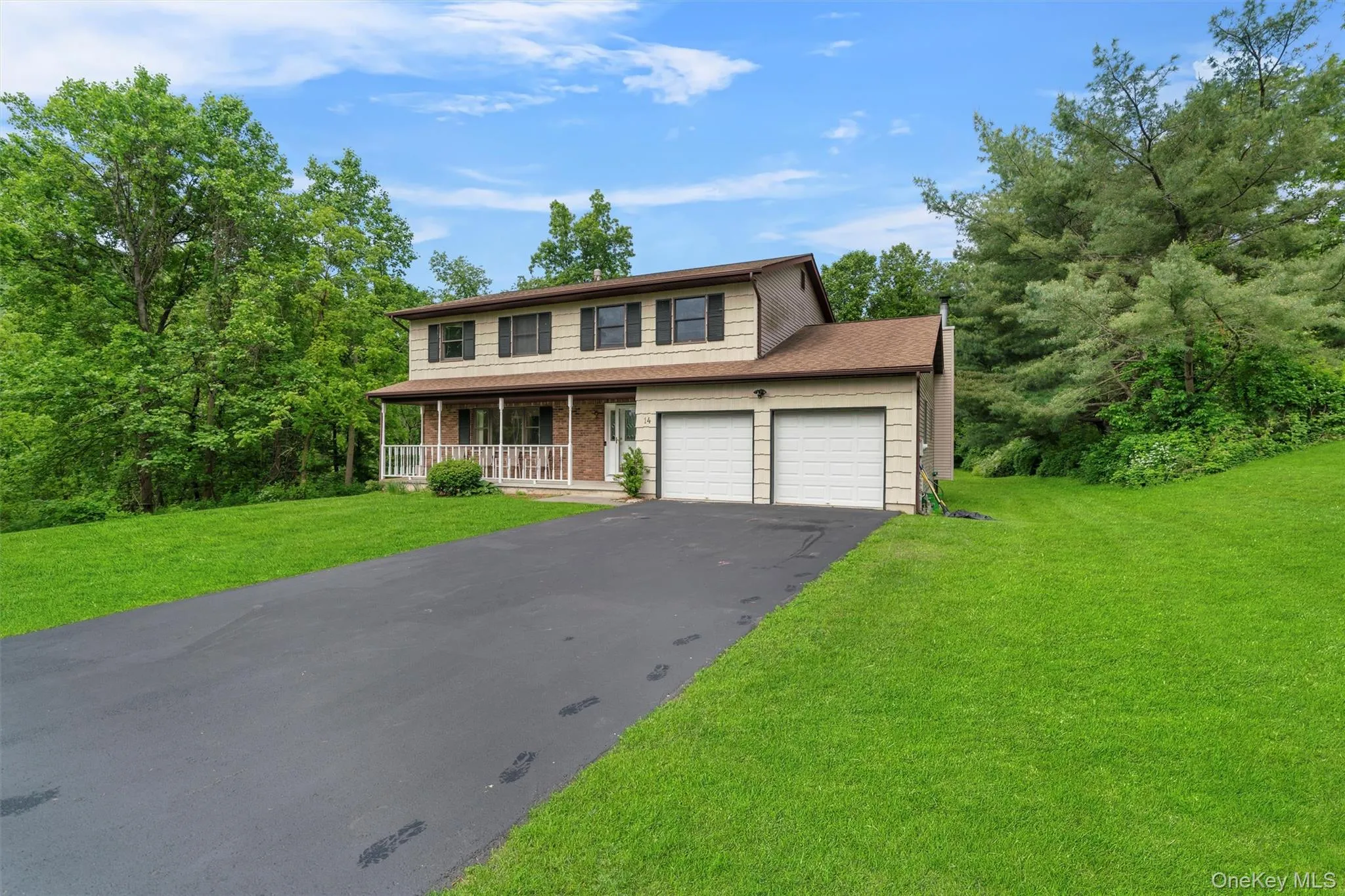 View of front of house featuring covered porch, a front yard, asphalt driveway, brick siding, and a shingled roof View of front of house featuring covered porch, a front yard, asphalt driveway, brick siding, and a shingled roof