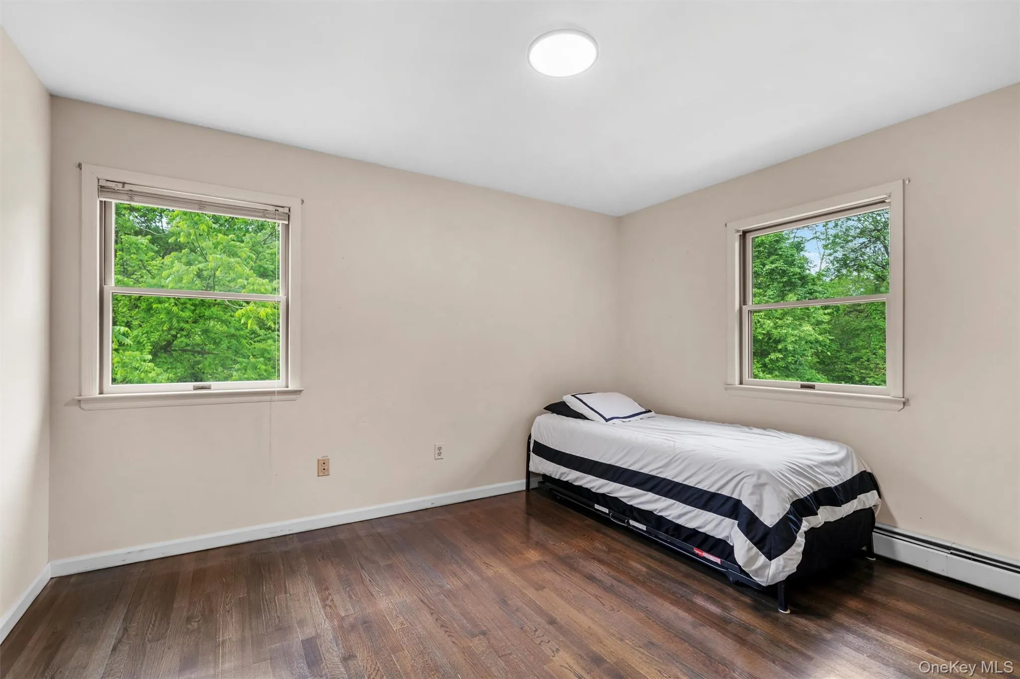 Bedroom featuring dark wood-style floors and baseboards Bedroom featuring dark wood-style floors and baseboards