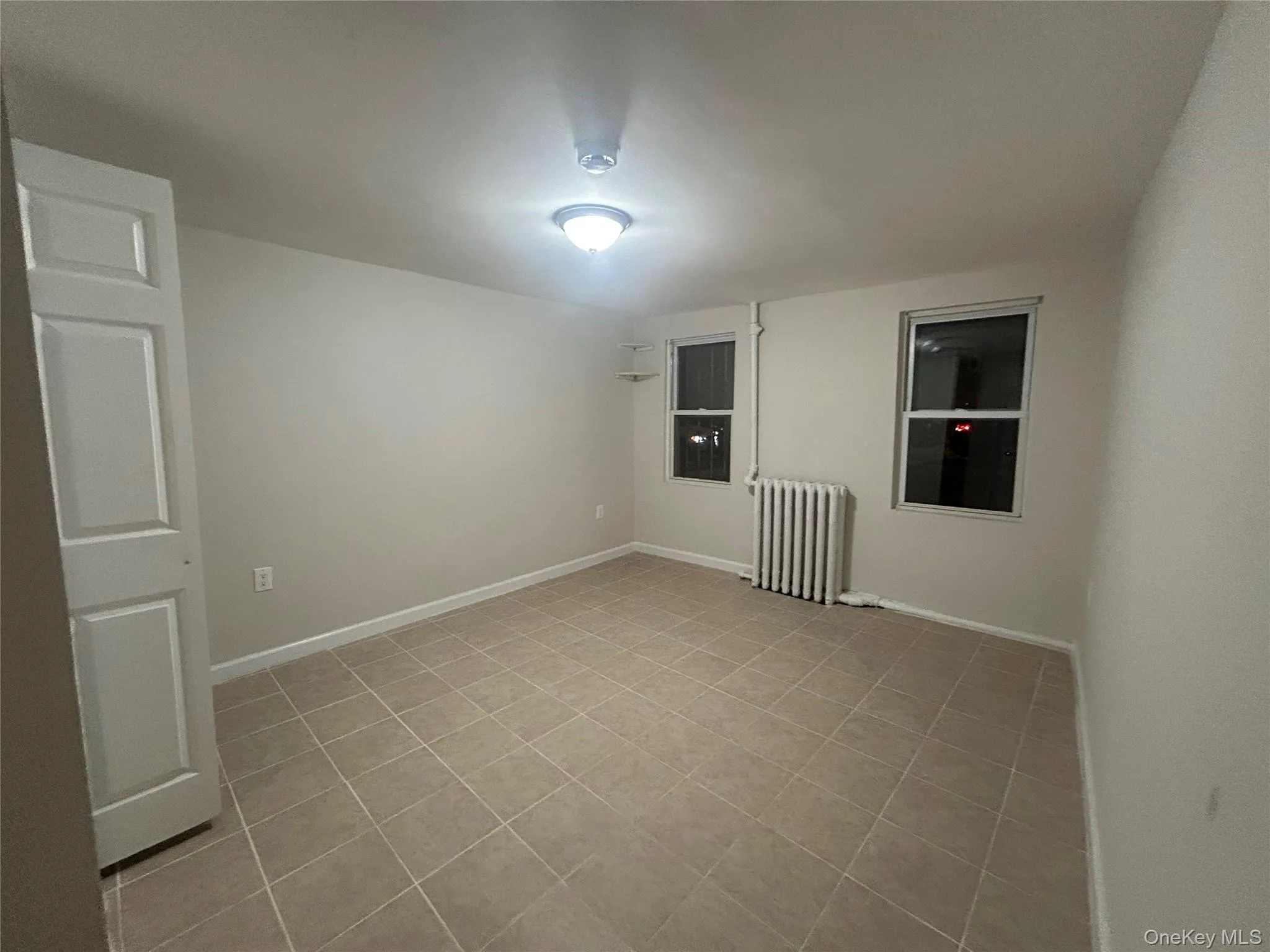 Unfurnished room featuring radiator and baseboards Unfurnished room featuring radiator and baseboards