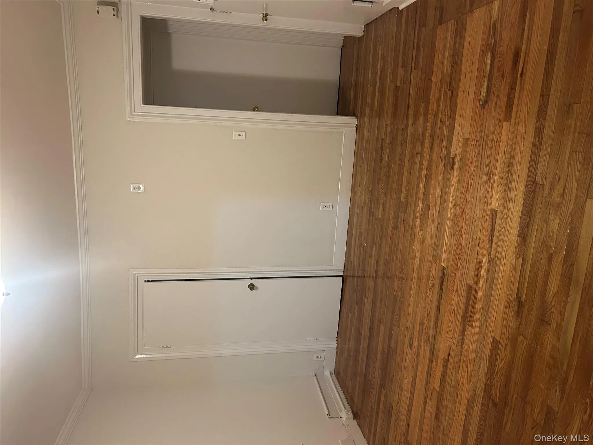 Empty room with dark wood-type flooring and crown molding Empty room with dark wood-type flooring and crown molding