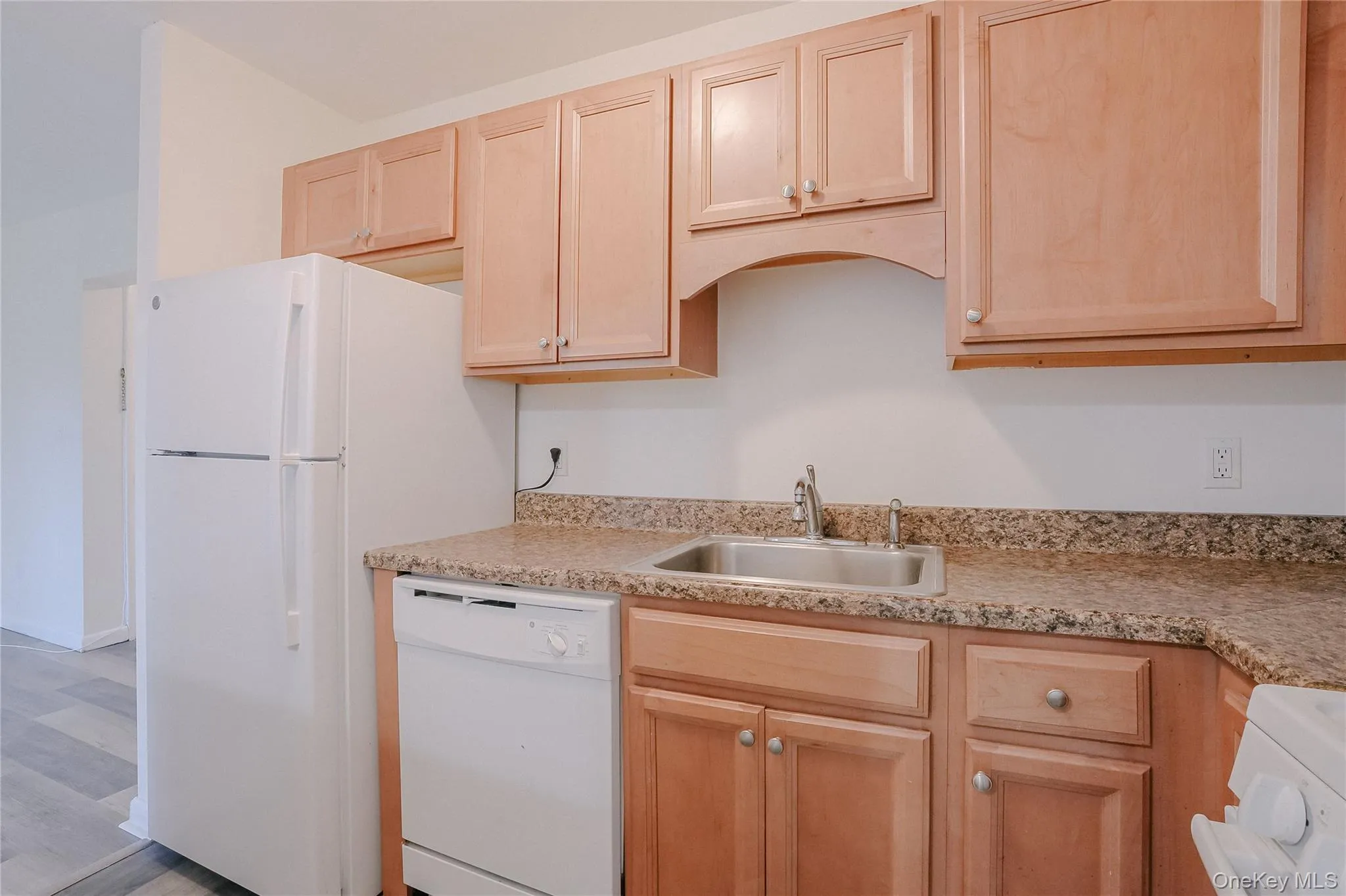 Kitchen featuring light brown cabinets, white appliances, and light wood-style floors Kitchen featuring light brown cabinets, white appliances, and light wood-style floors
