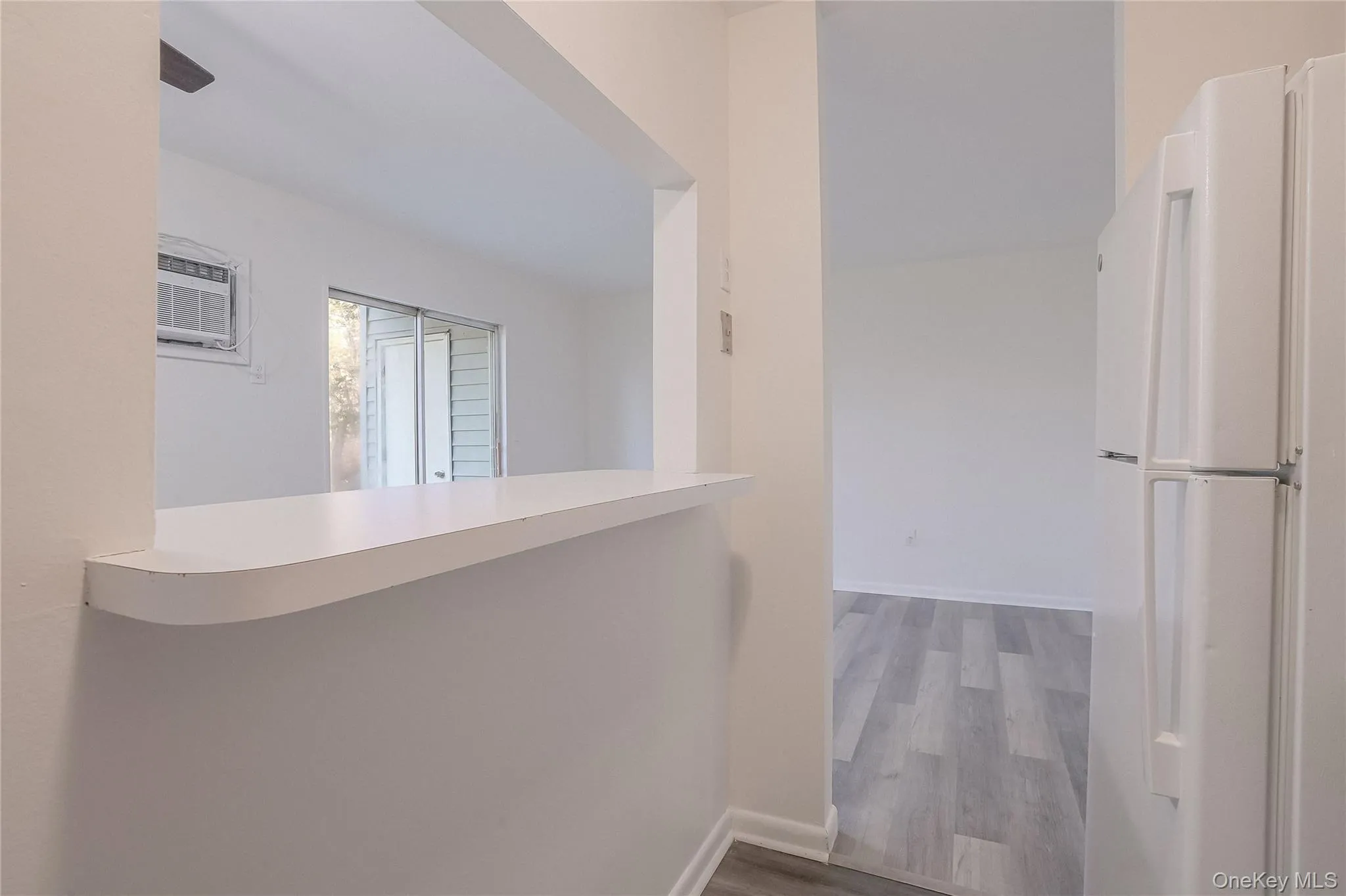 Corridor featuring light wood-style flooring and a wall mounted AC Corridor featuring light wood-style flooring and a wall mounted AC