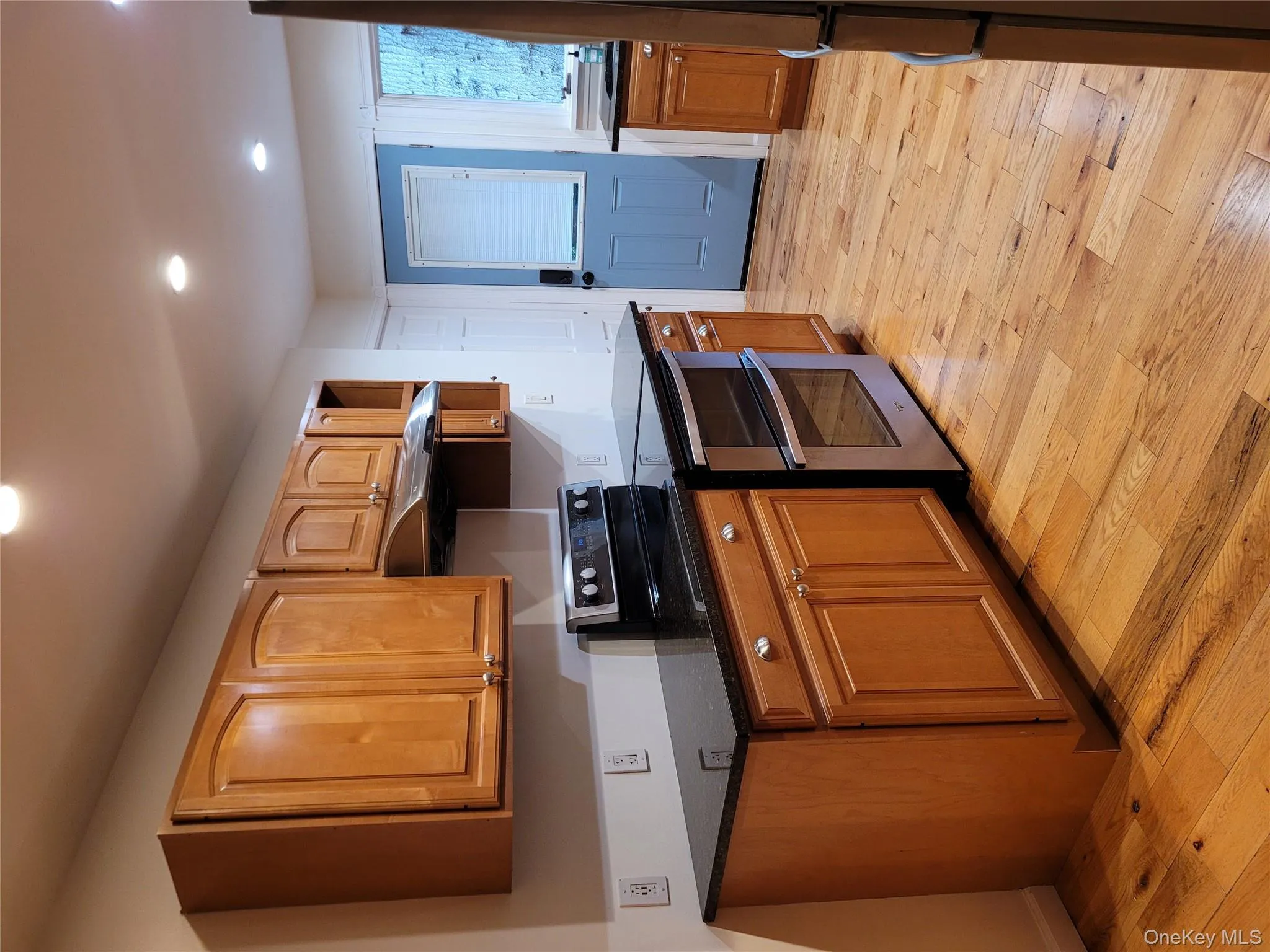 Kitchen featuring stainless steel electric range oven, extractor fan, light wood-style flooring, recessed lighting, and fridge Kitchen featuring stainless steel electric range oven, extractor fan, light wood-style flooring, recessed lighting, and fridge