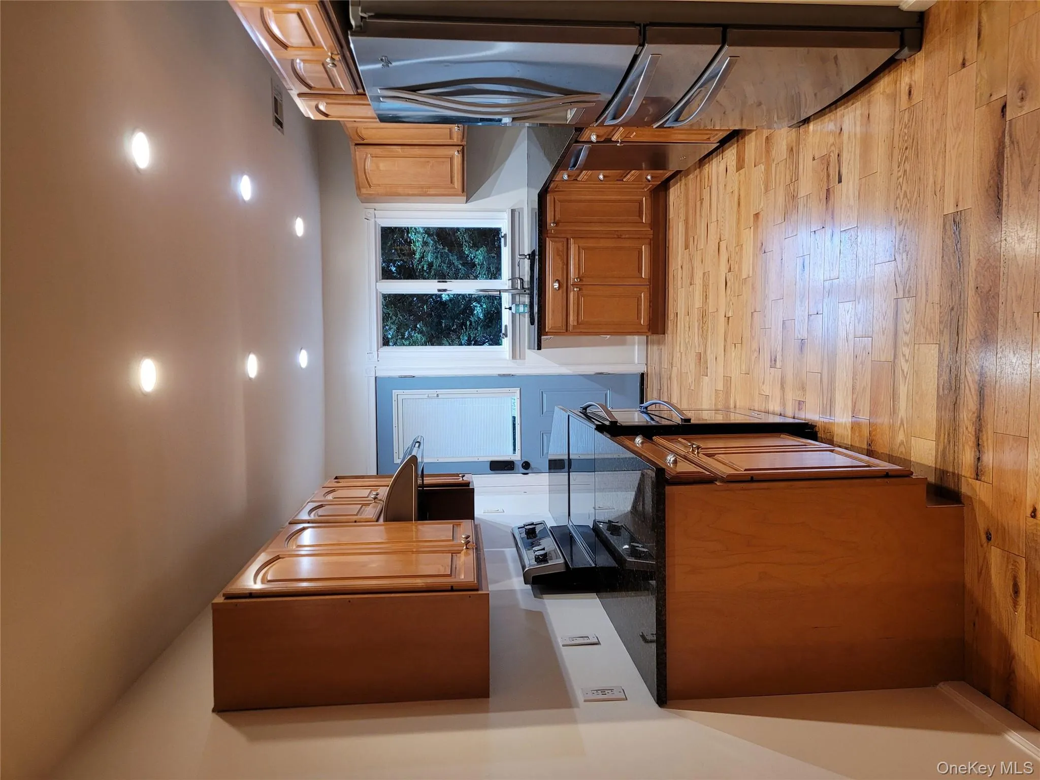 Kitchen featuring fridge, range, dishwasher, exhaust hood, and light wood finished floors Kitchen featuring fridge, range, dishwasher, exhaust hood, and light wood finished floors