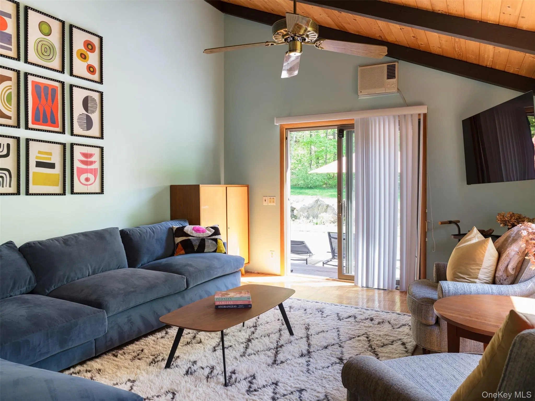 Living area with a wooden ceiling with exposed beams, ceiling fan, and high vaulted ceiling Living area with a wooden ceiling with exposed beams, ceiling fan, and high vaulted ceiling