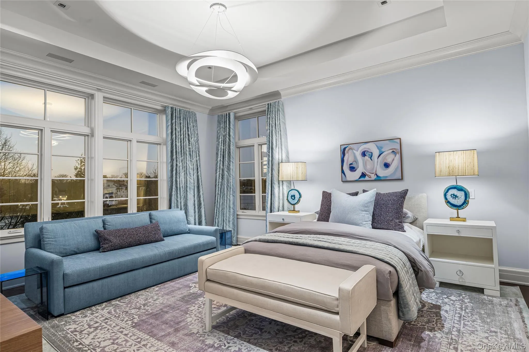 Bedroom featuring a tray ceiling and wood finished floors Bedroom featuring a tray ceiling and wood finished floors