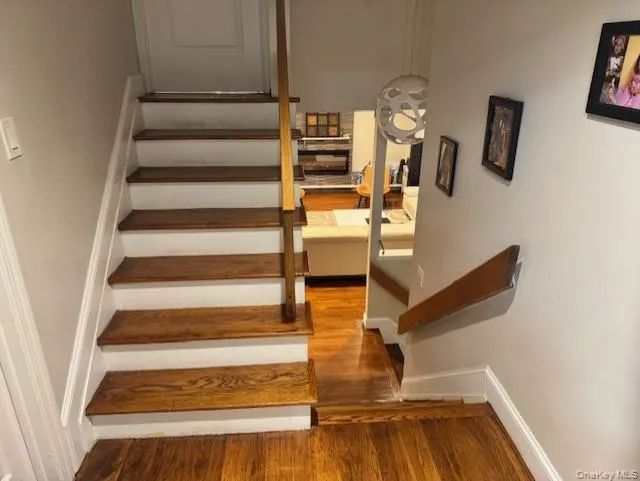 Staircase with baseboards and wood finished floors Staircase with baseboards and wood finished floors