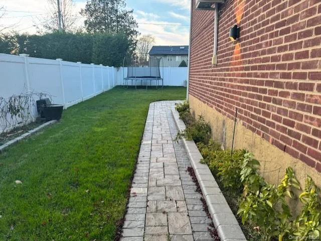 Fenced backyard featuring a trampoline Fenced backyard featuring a trampoline