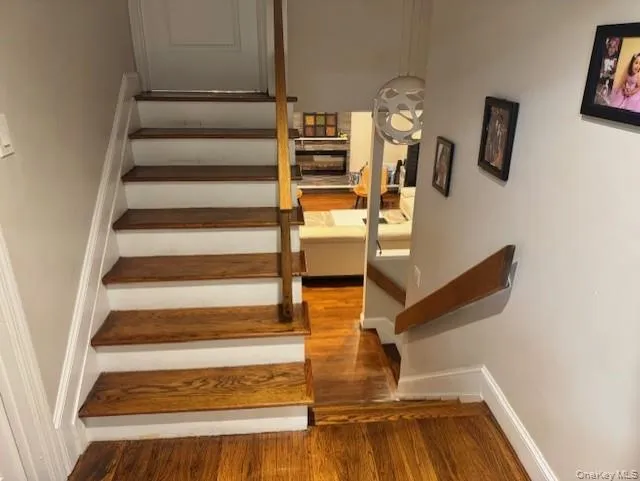 Stairway featuring wood finished floors and baseboards Stairway featuring wood finished floors and baseboards