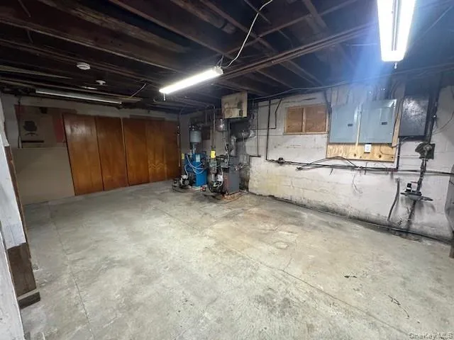 Unfinished basement with electric panel and a heating unit Unfinished basement with electric panel and a heating unit