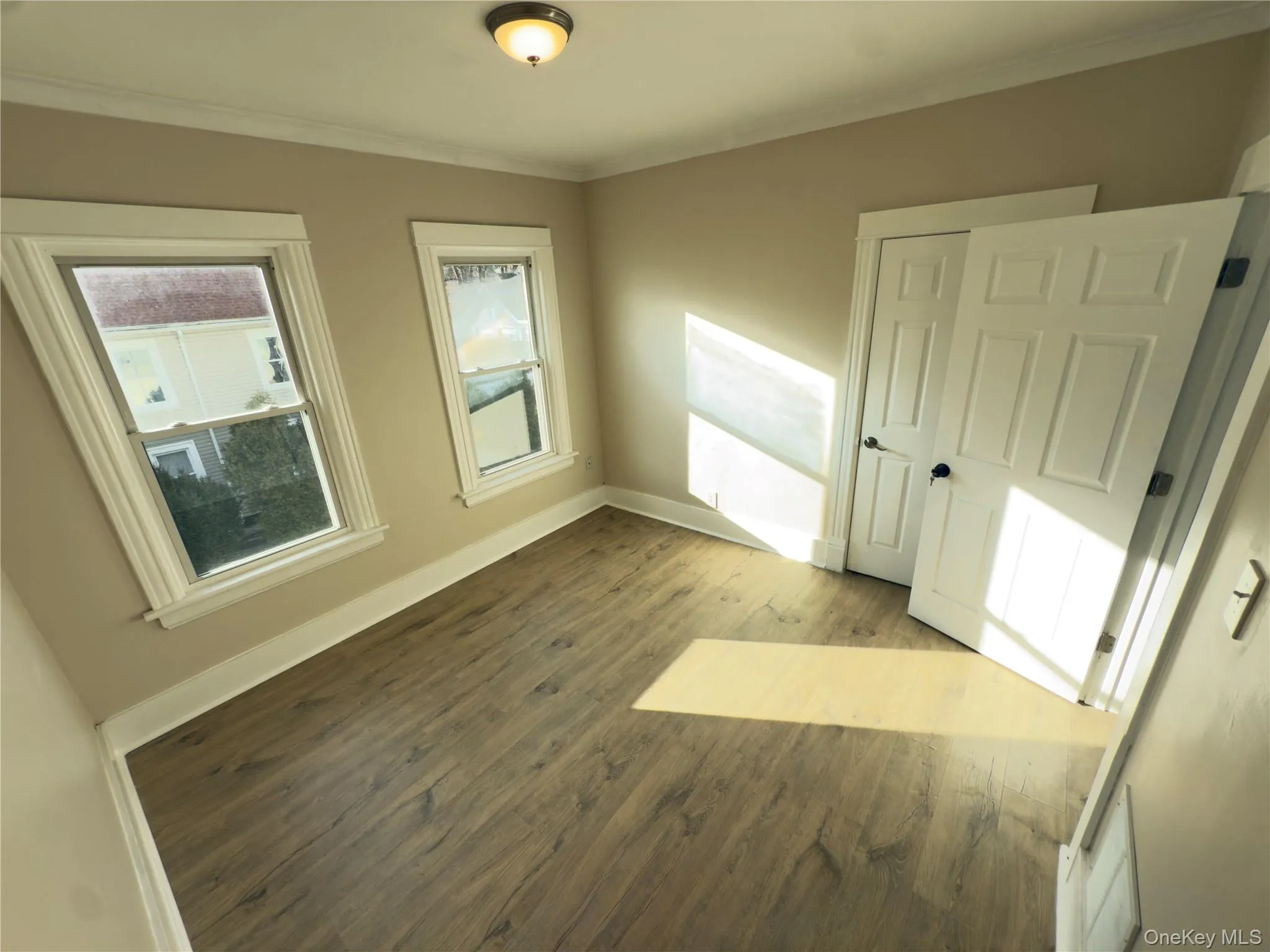 Unfurnished bedroom with wood finished floors and crown molding Unfurnished bedroom with wood finished floors and crown molding