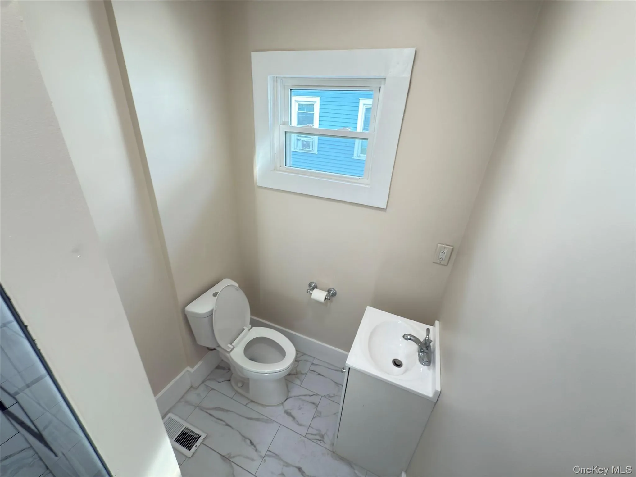 Bathroom featuring light marble finish floors and vanity Bathroom featuring light marble finish floors and vanity