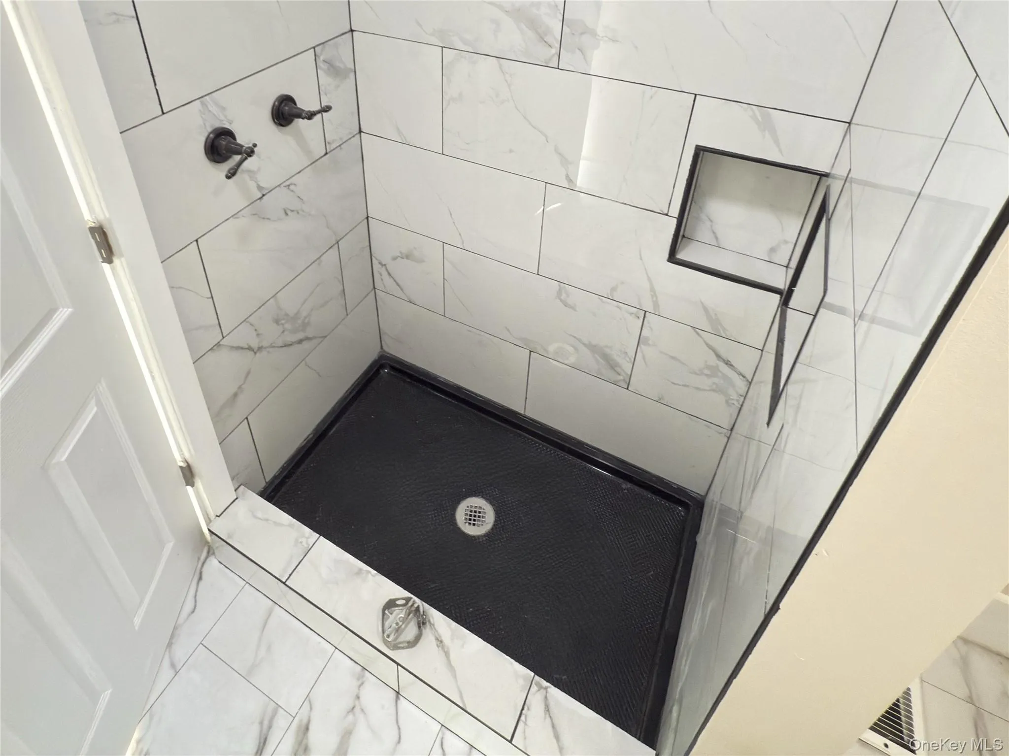 Full bath with a stall shower and marble look tile flooring Full bath with a stall shower and marble look tile flooring