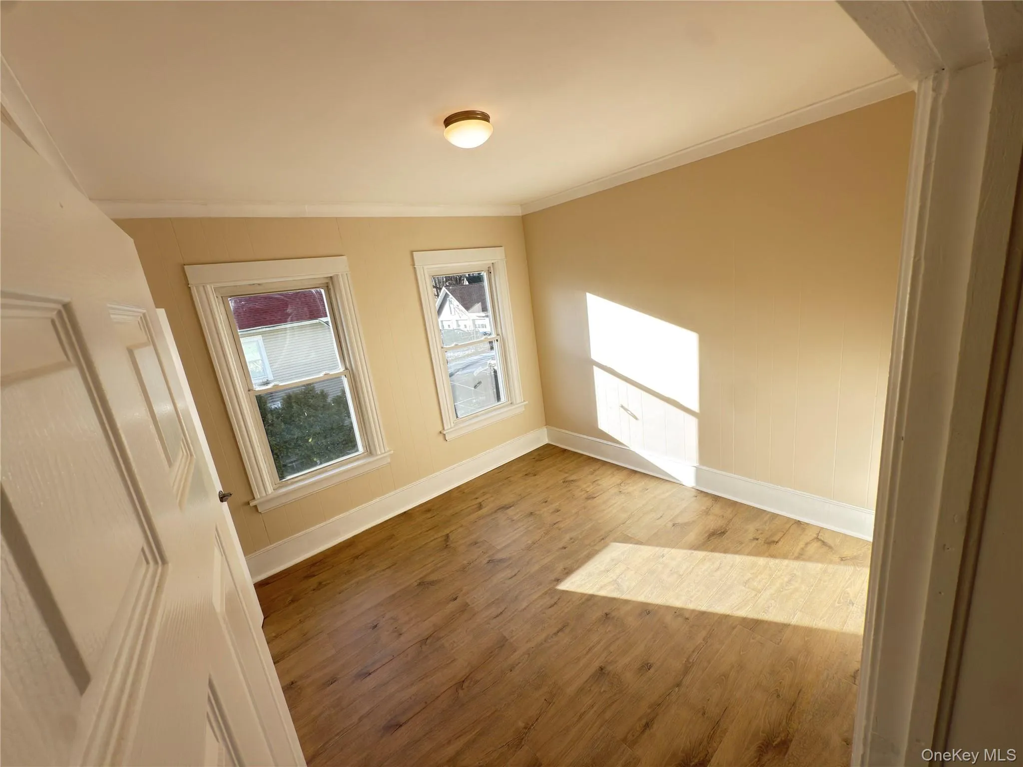 Unfurnished room featuring crown molding and wood finished floors Unfurnished room featuring crown molding and wood finished floors