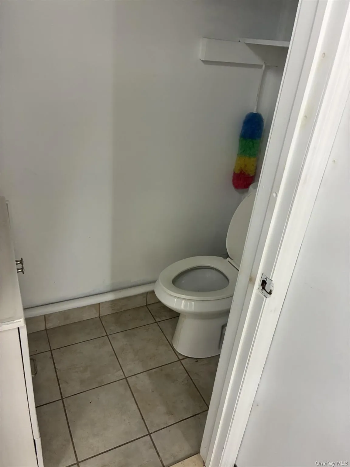 Bathroom featuring toilet and light tile patterned floors Bathroom featuring toilet and light tile patterned floors